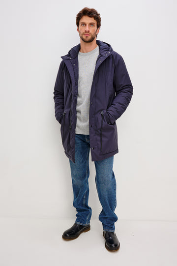 Rainier is a hooded parka coat, water-resistant and features hand warming pockets with snap closure, drawcord at hood and waist for sinching effect and a double flap center front closure and back seam vent in Navy colorway. Front full body view featured on model.