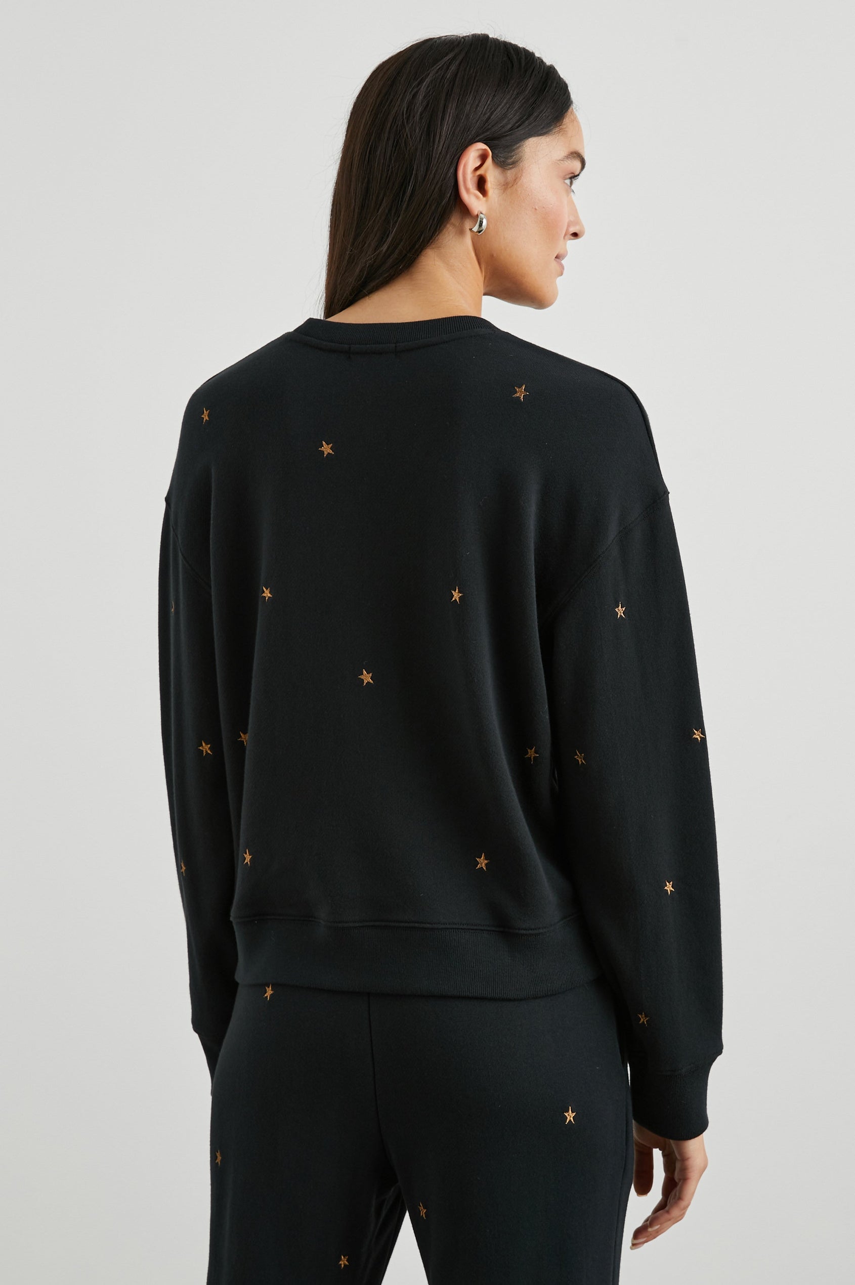 Ramona Long-Sleeve Sweatshirt with a Crew Neck in Bronze Star Embroidery Colorway, Bronze Stars on Black - Back View Featured on Model