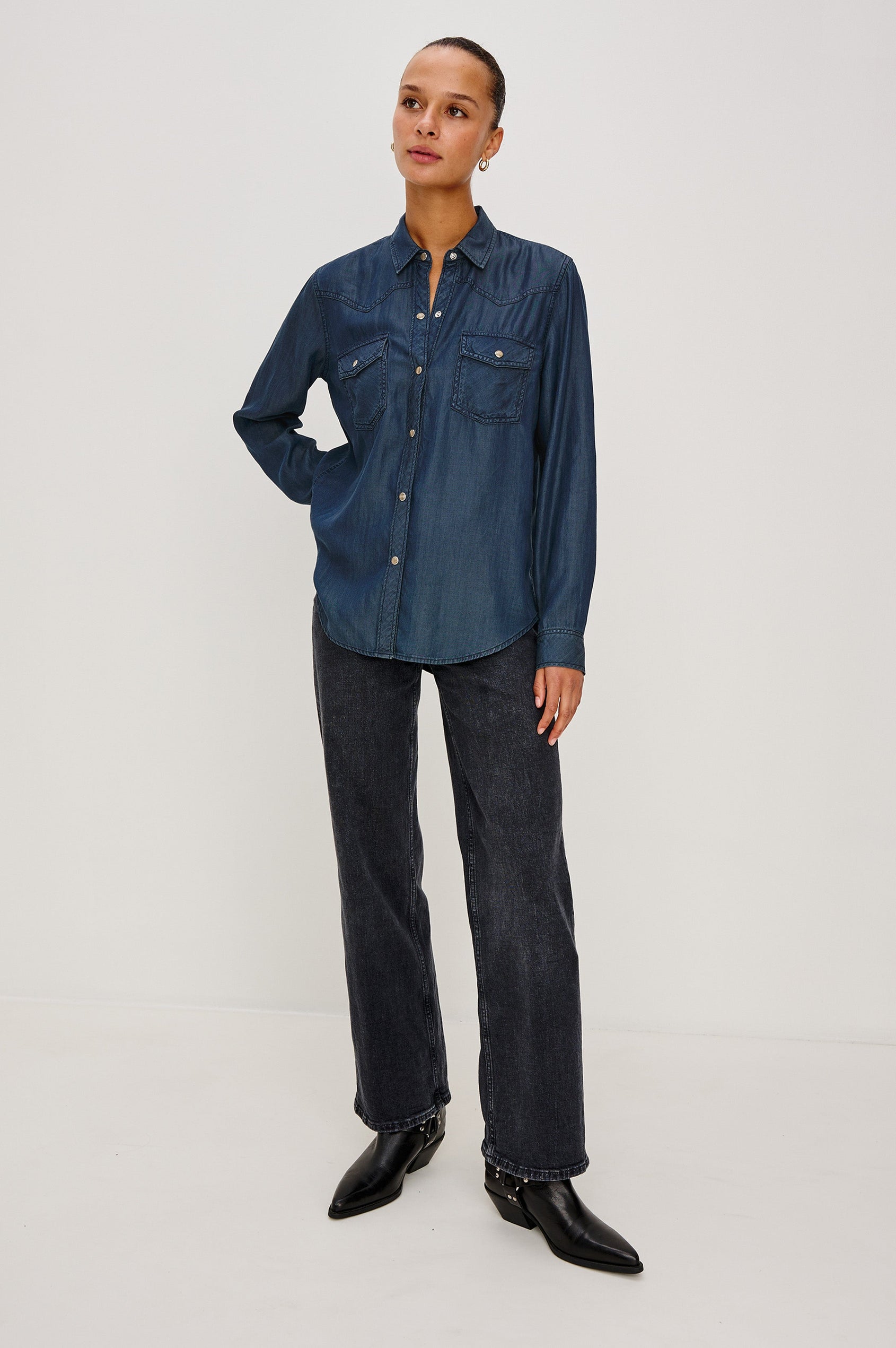 Remi is a utility-style Tencel denim shirt with a relaxed fit. The shirt features a notched collar, two front flap pockets, and faux horn buttons etched with a logo in Oceana dark blue colorway - Full Body Front View Featured on Model