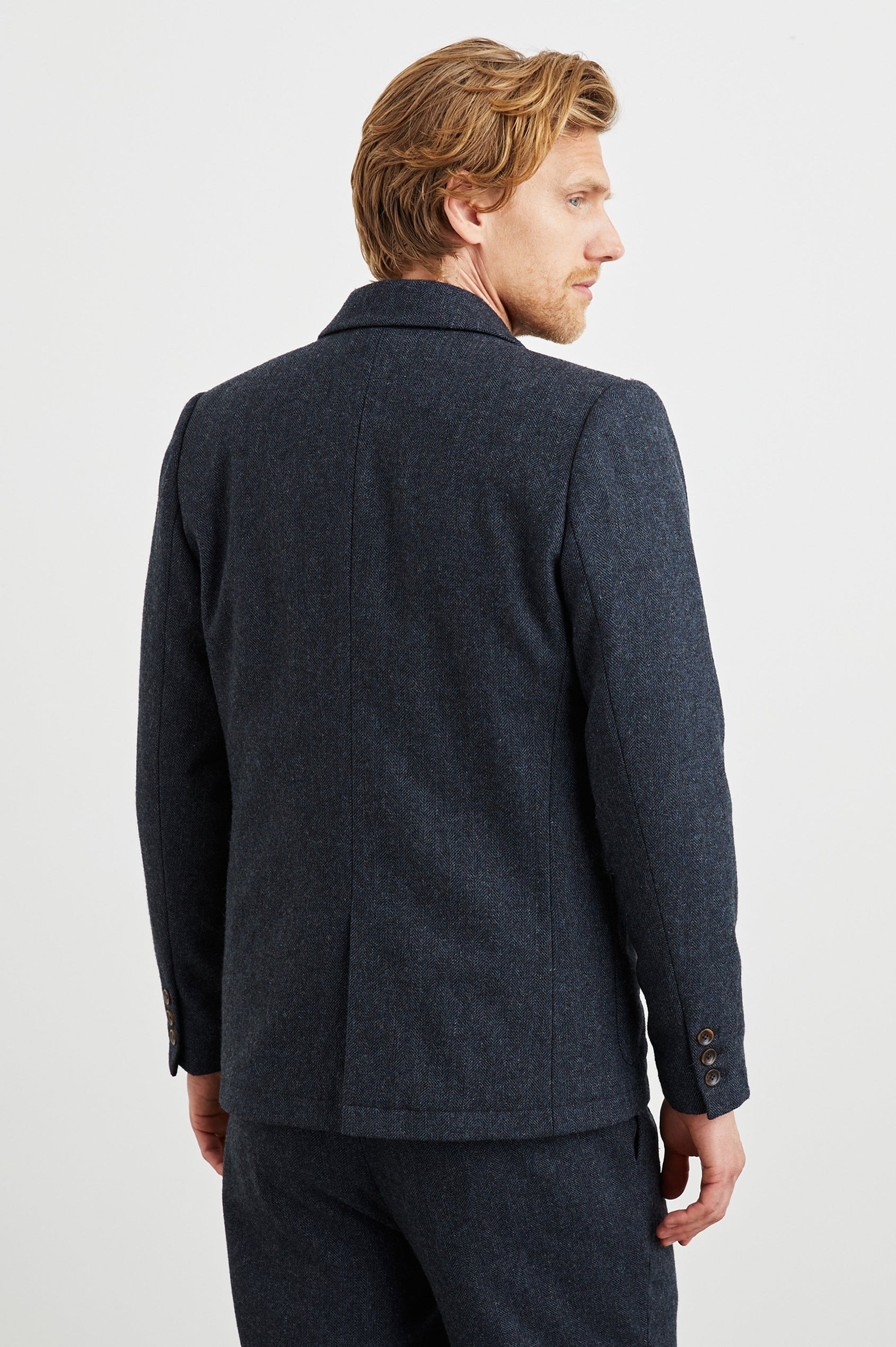 Reynard Blazer with Two Button Closure, Two Front Pockets, a Chest Welt Pocket, Herringbone Fabric in Celestial Tweed Colorway - Back View Featured on Model