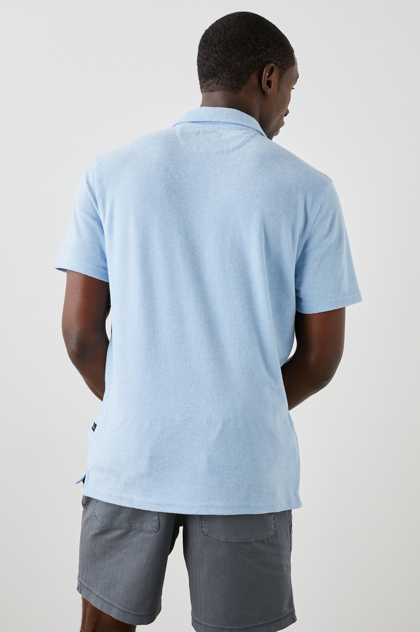 Rhen Short-Sleeve Polo Shirt with a Three-Button Placket in Terry Chambray Blue Colorway - Back View Featured on Model