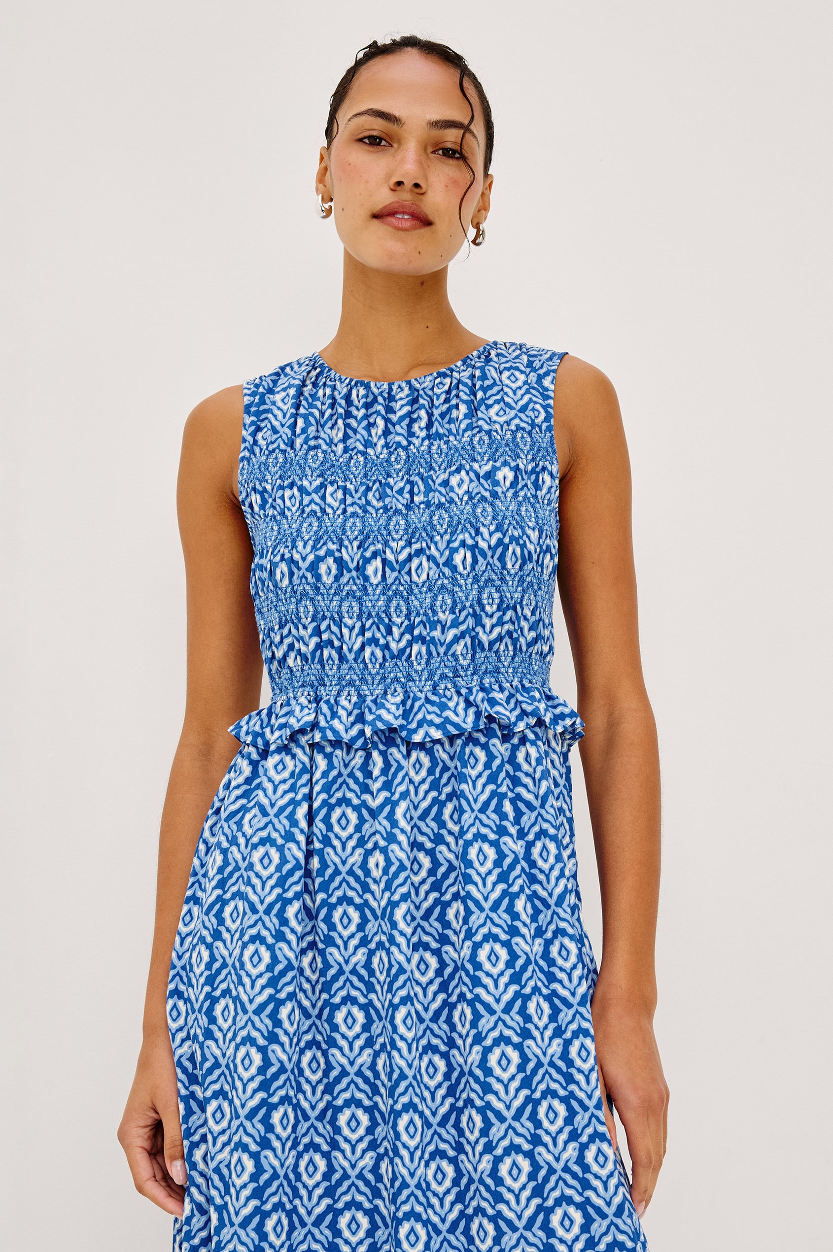 Rialto Midi Dress in Cotton Poplin With High Neckline, Smocked Bodice, Sleeveless Cut, Ruffle Trim, and Tiered Hem in Blue Ikat Colorway - Upper Body Front View Featured on Model