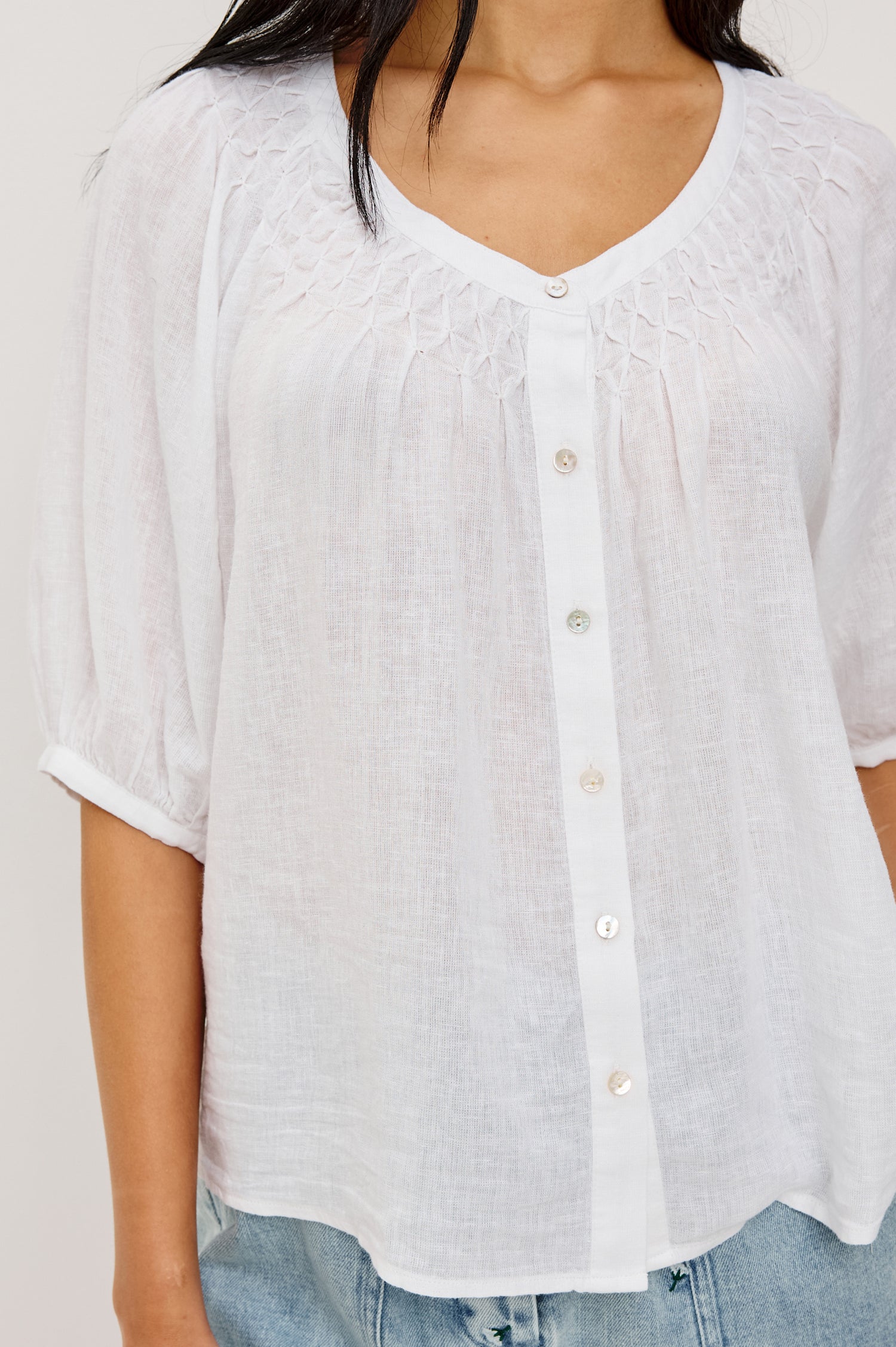 Rix Relaxed Button-Up Top in Linen With Scoop Neckline, Smocked Yoke, and Elbow Length Raglan Sleeves in White Colorway - Upper Body Front View Featured on Model