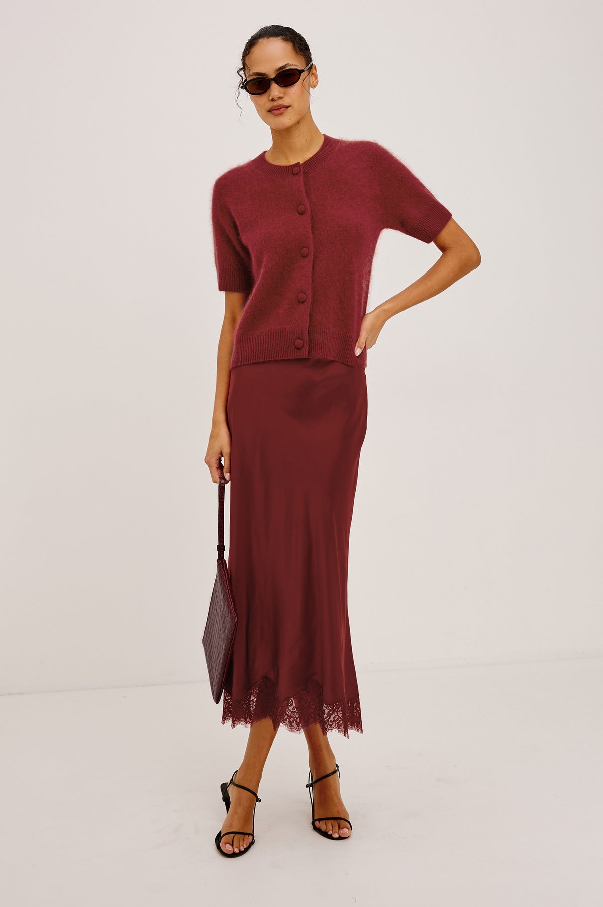 Ebony Midi Skirt Bias Cut in Satin With Clean Elastic Waistband, Pull-On Fit, and Tonal Lace Trim at Hem in Crimson Colorway - Full Body Front View Featured on Model