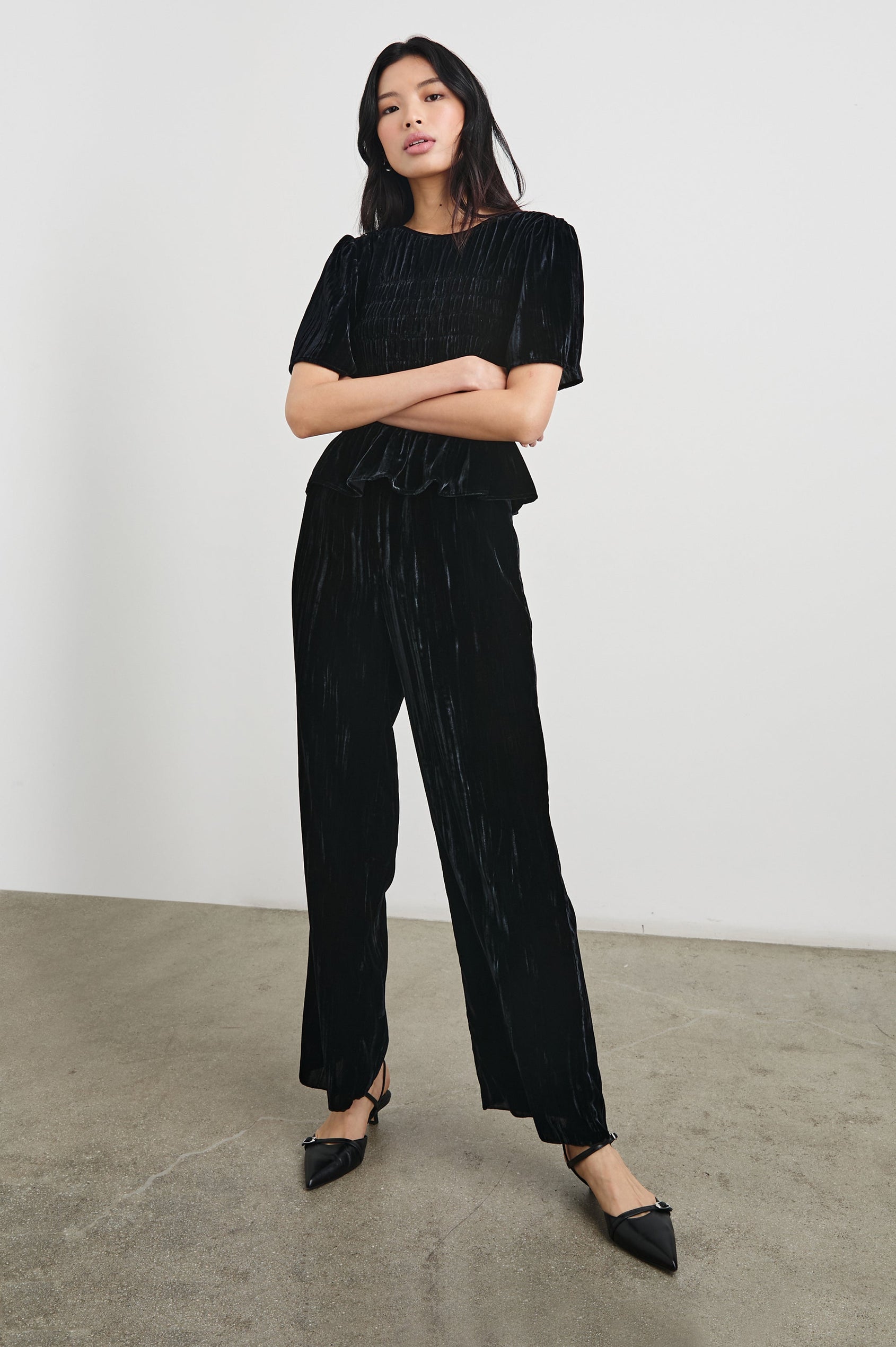 Rosie Short-Sleeve Top with a Smocked Center Bodice, Pleats at the Hem and Yoke and a Upper Back Button Closure in Black Velvet Colorway - Front View Full Body Featured on Model