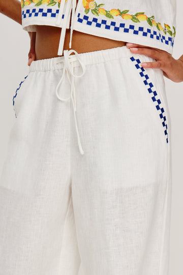 Rosita linen pant in Sorrento Embroidery colorway featuring side pockets, drawstring waist, and Italian inspired embroidery - close up of details on model