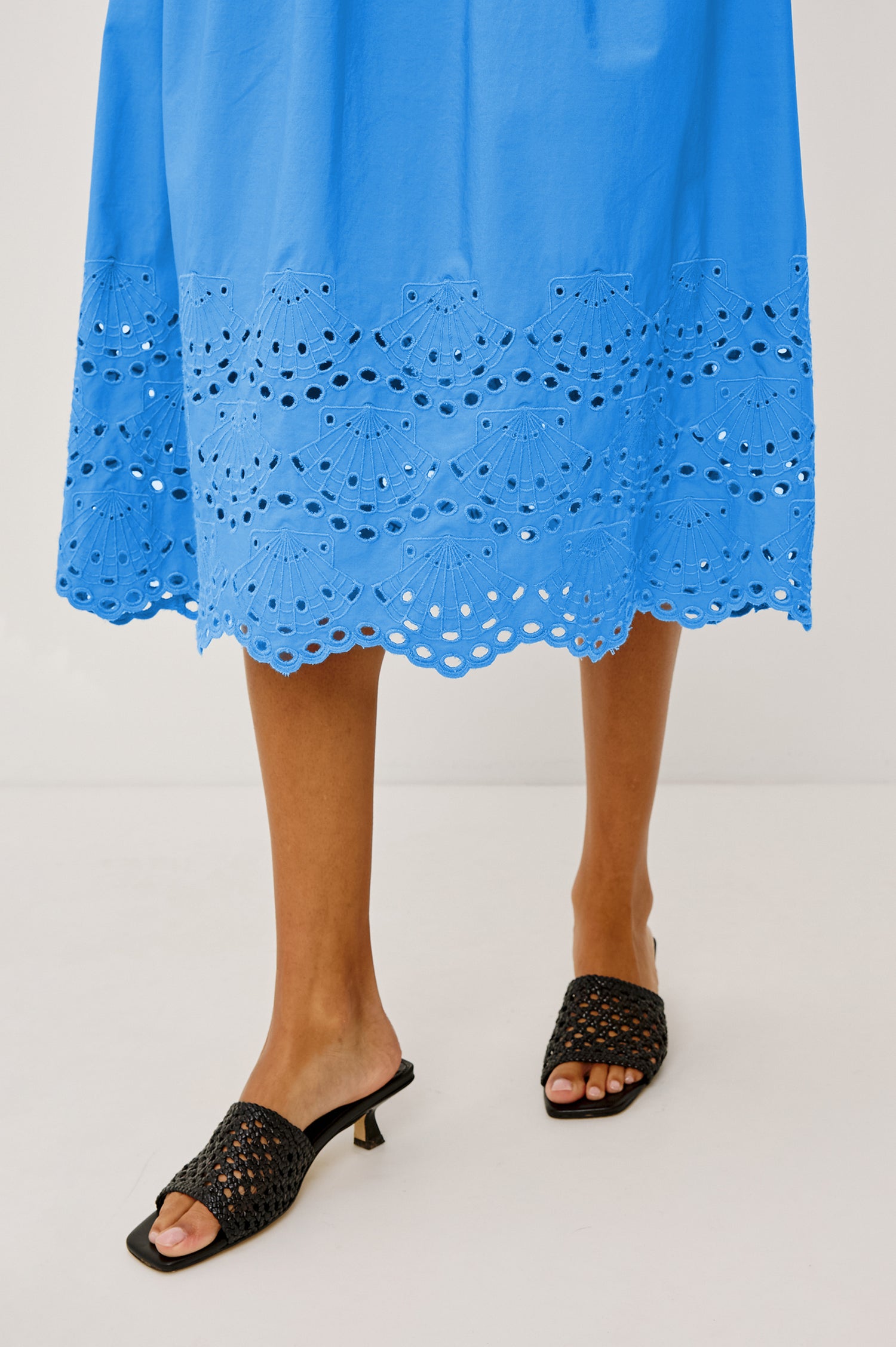 Roxanne Midi Dress in Cotton Poplin With Shirred Shoulders, Plunging V-Neck, Smocked Waist and Seashell Hem Embroidery in Harbor Blue Colorway - Hem Close Up View Featured on Model