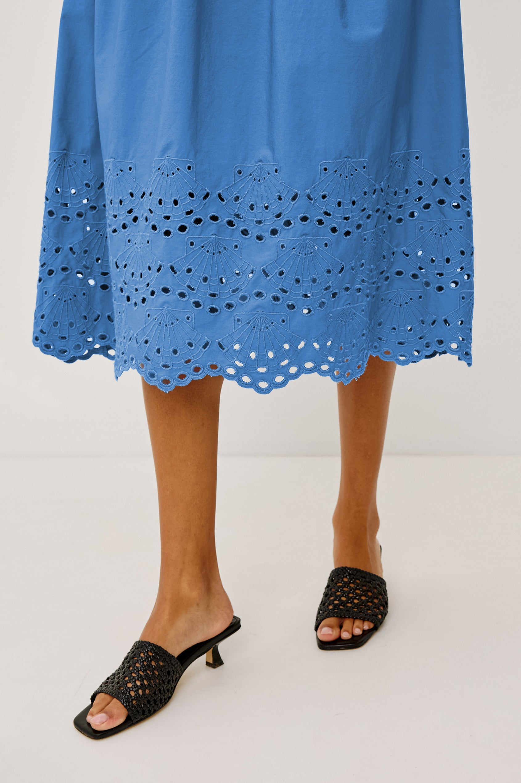 Roxanne Midi Dress in Cotton Poplin With Shirred Shoulders, Plunging V-Neck, Smocked Waist and Seashell Hem Embroidery in Harbor Blue Colorway - Hem Close Up View Featured on Model