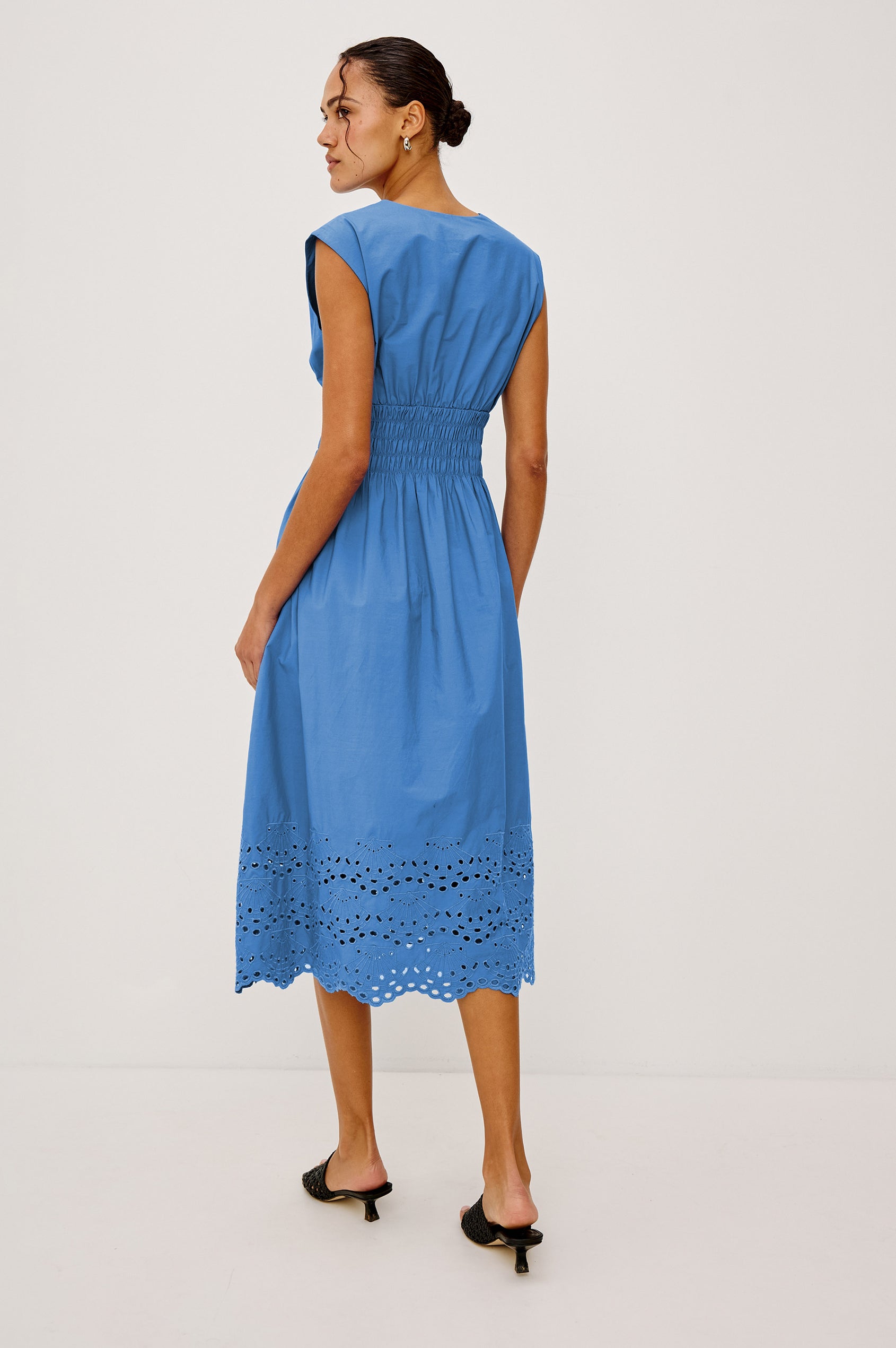 Roxanne Midi Dress in Cotton Poplin With Shirred Shoulders, Plunging V-Neck, Smocked Waist and Seashell Hem Embroidery in Harbor Blue Colorway - Full Body Back View Featured on Model