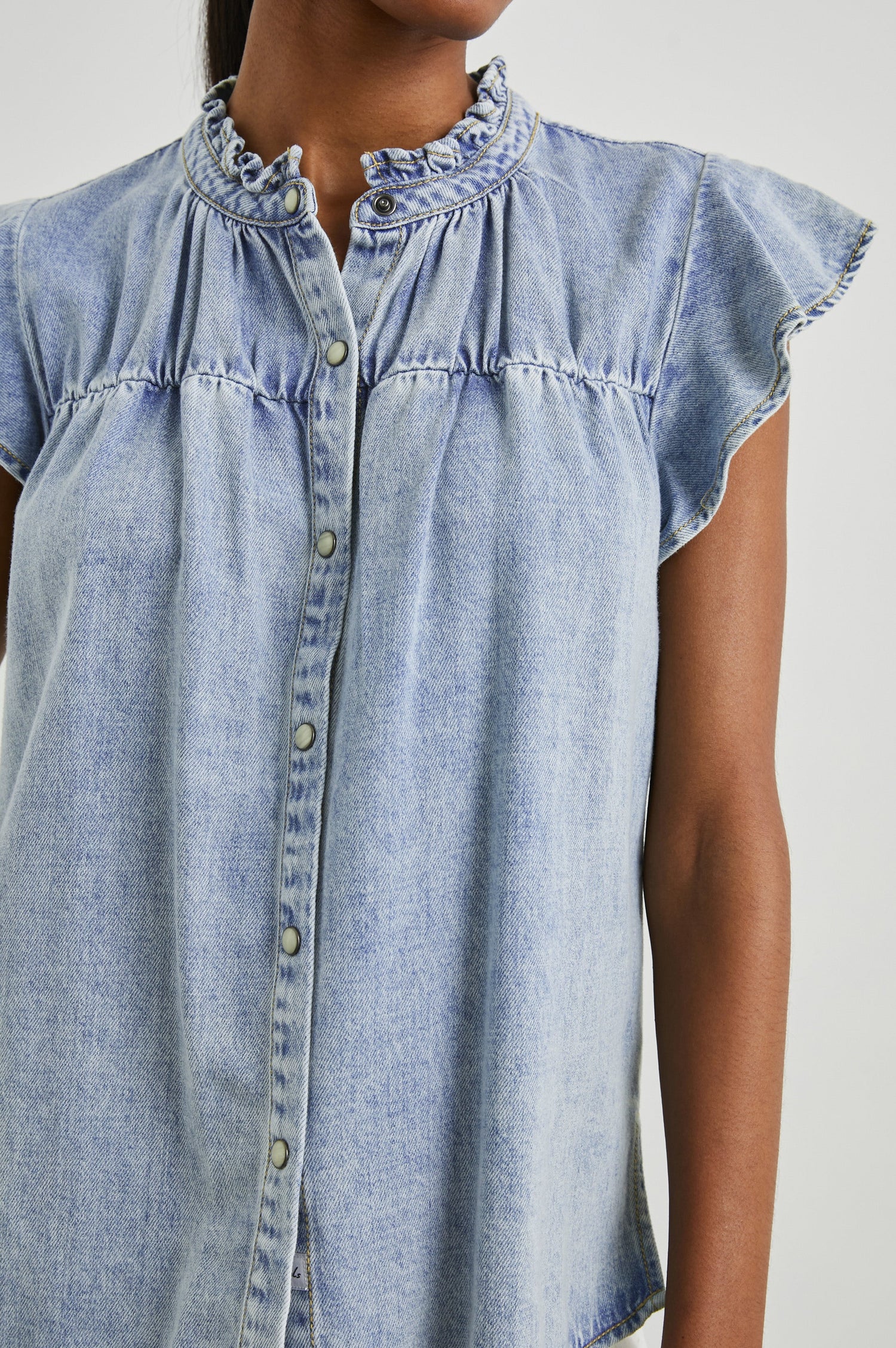 Ruthie Top with Flutter Cap Sleeves, a Ruffled Banded Collar, Buttons Down the Front, and Soft Shirring at Front Yoke in Faded Indigo Colorway - Front  View Featured on Model