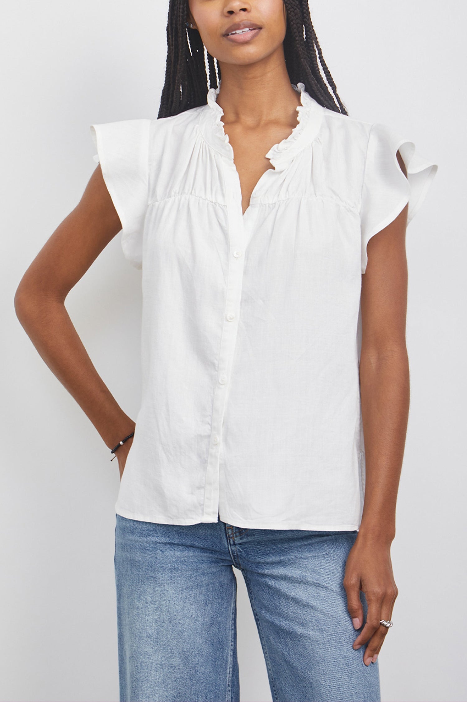 Ruthie Top with Flutter Cap Sleeves, a Ruffled Banded Collar, Buttons Down the Front, and Soft Shirring at Front Yoke in White Colorway - Front  View Featured on Model