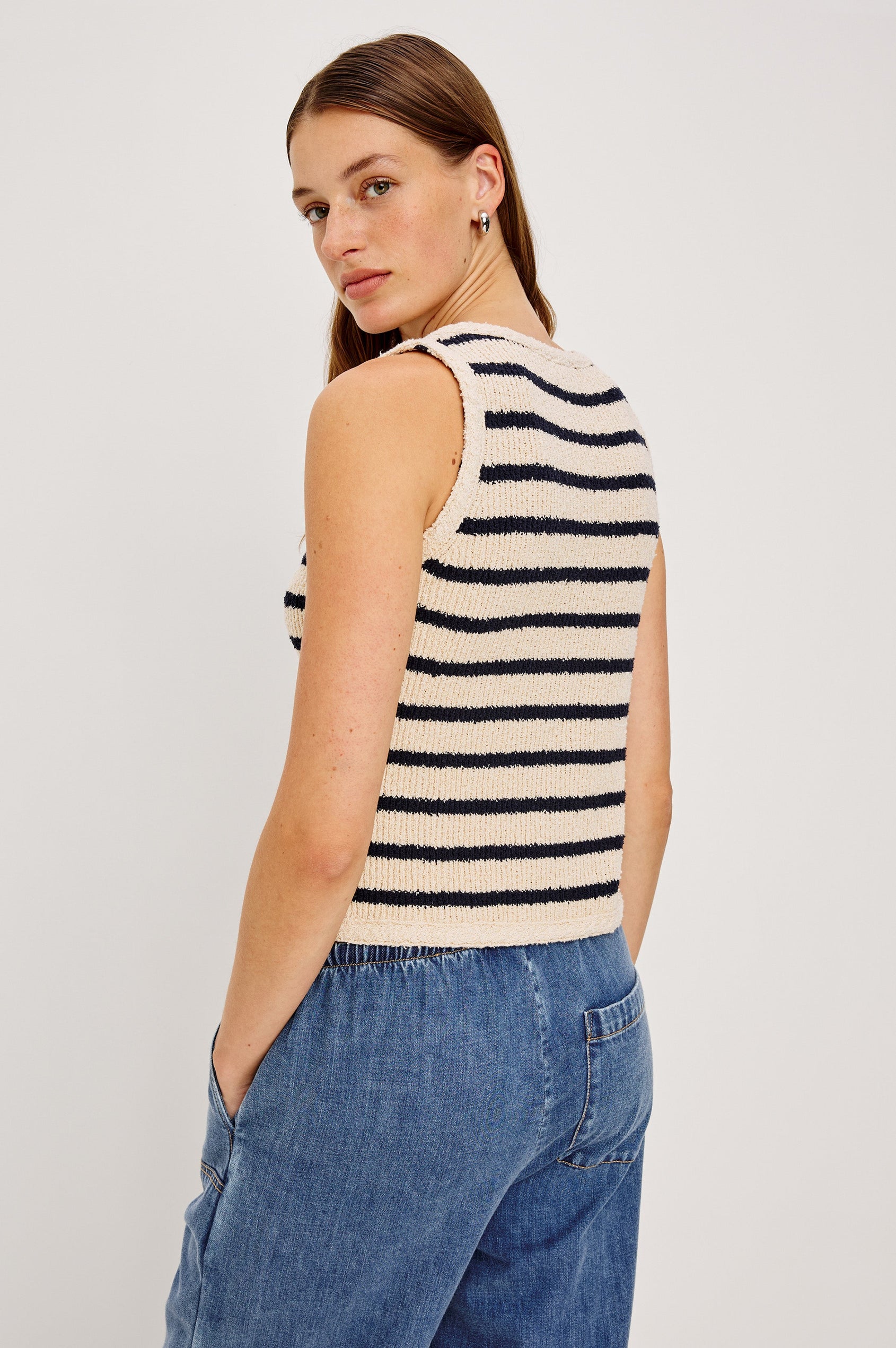 The Sade is a button front sweater vest with a v-neck in Ivory Navy Stripe colorway. Back view featured on model. 