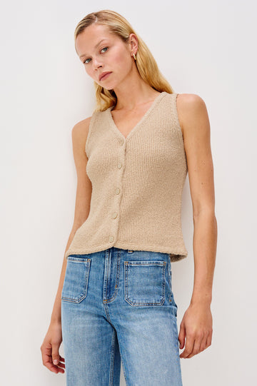 Soft cotton vest in a neutral Oat Colorway. The vest features subtle ribbing, a full-button front, and is styled on its own for a clean, minimalist look. Front view featured on model.
