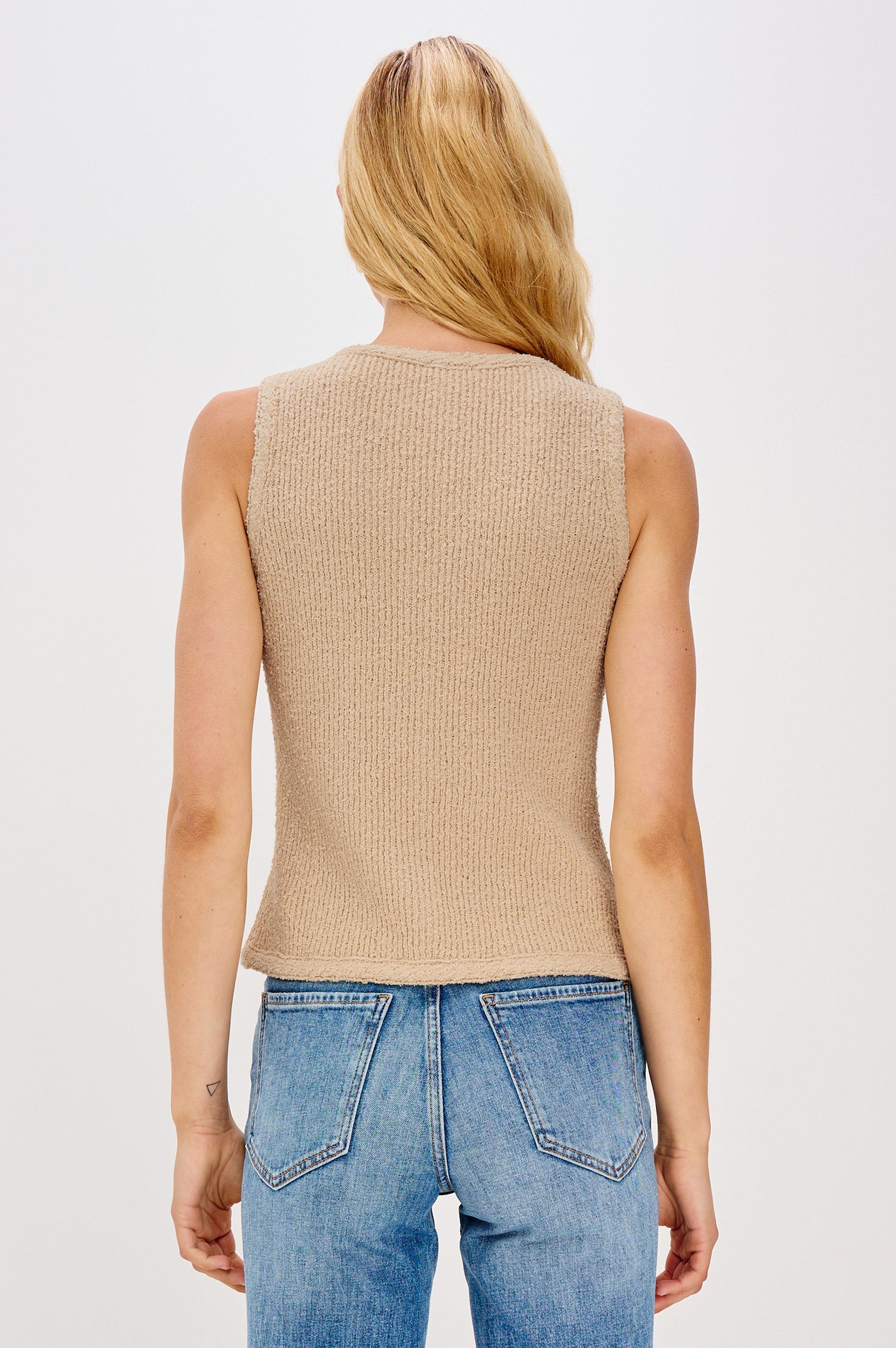 Soft cotton vest in a neutral Oat Colorway. The vest features subtle ribbing, a full-button front, and is styled on its own for a clean, minimalist look. Back view featured on model.