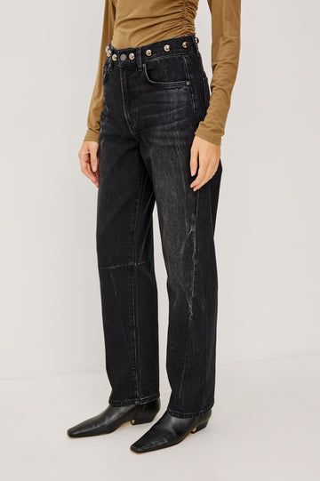 Samo Barrel Jean in Subtle Stretch Denim With Metallic Nail-Back Studs at Waist, 5-Pockets, and Front Zip-Fly in Black Stone Studded Colorway - Lower Body Side View Featured on Model