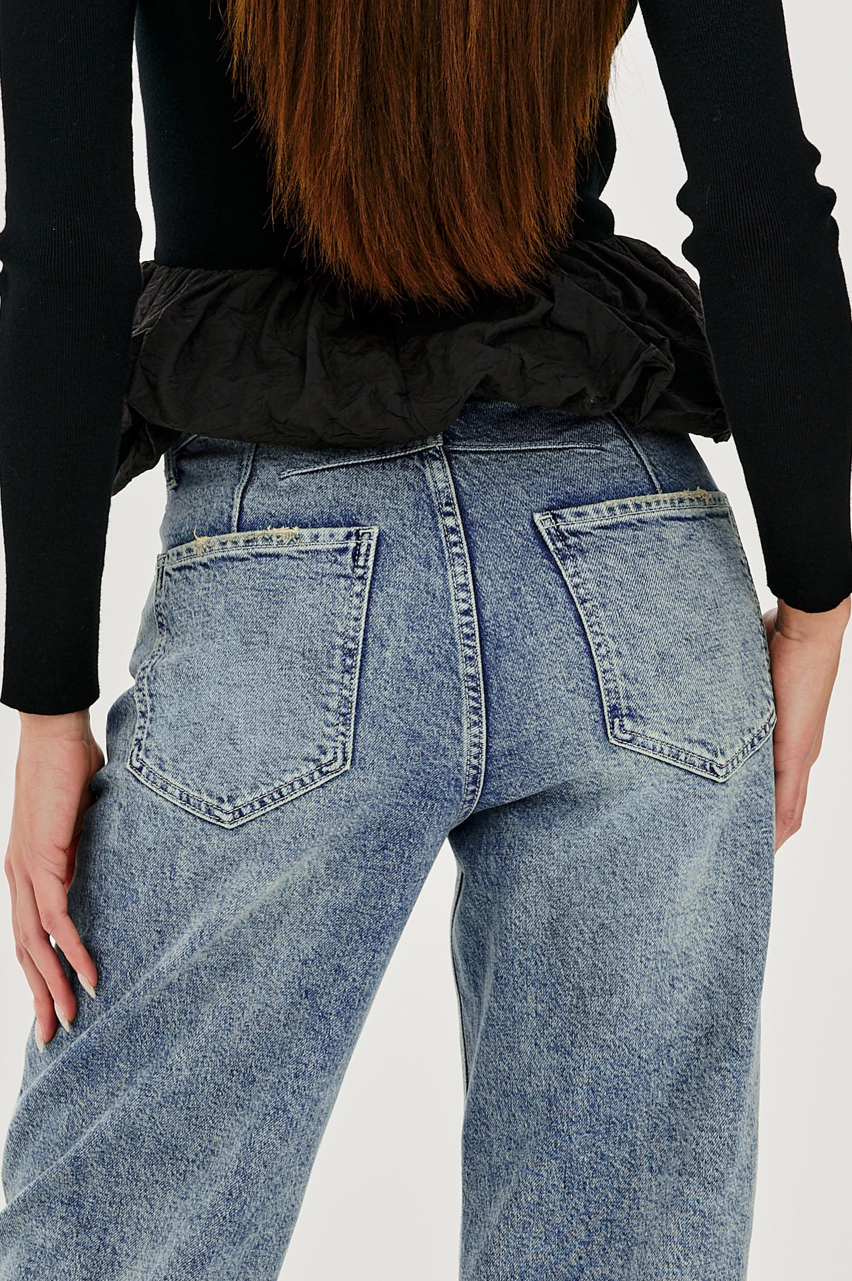 The Samo is a denim barrel leg jean, it features a low-slung fit in light-stretch denim with darting details and a subtle curved seam in Desert Sky wash, a vintage wash with yellow tint. Back detail view featured on model.