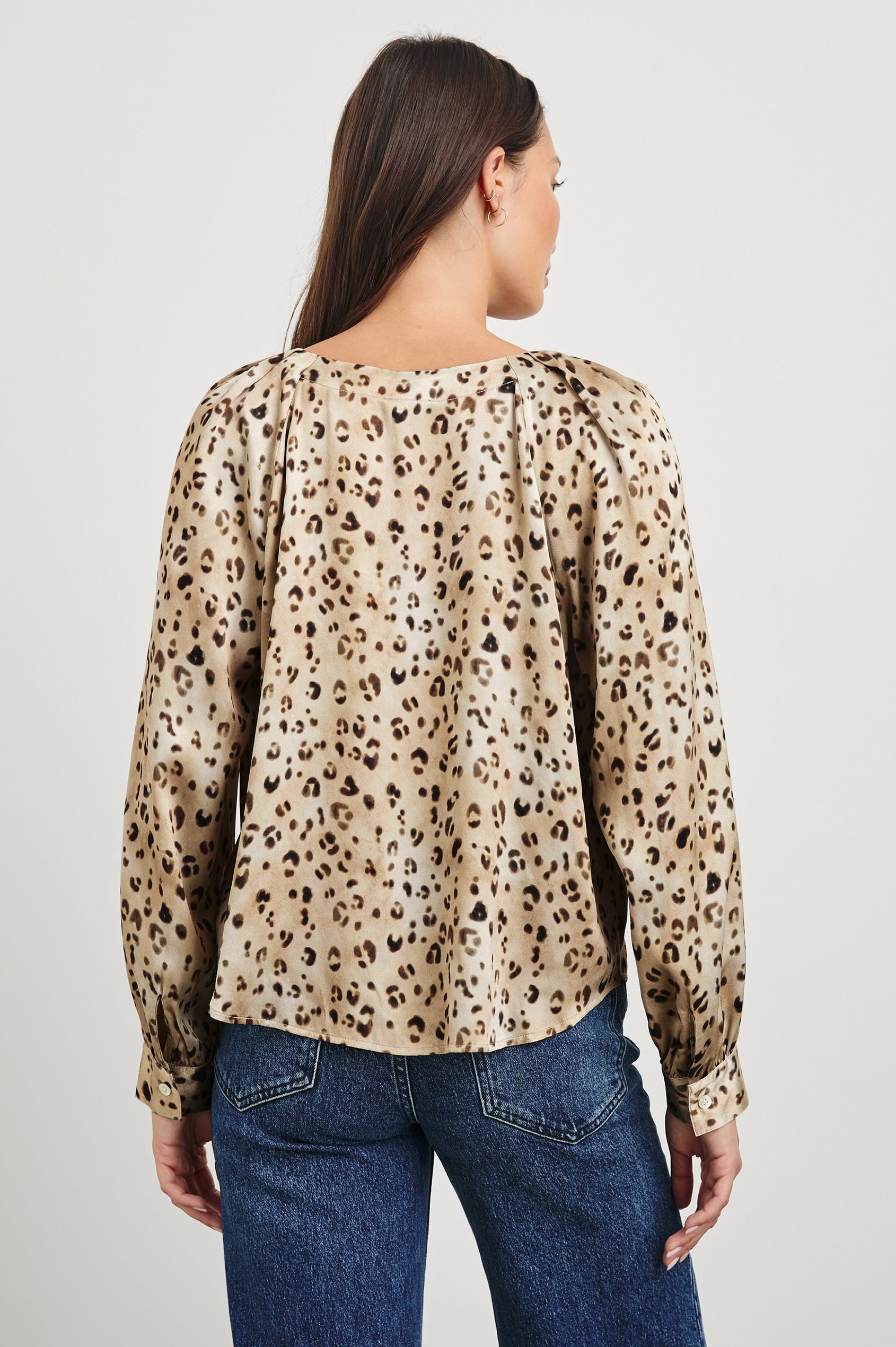 Sandra Long-Sleeve Faux Wrap Blouse with a Deep V Neck and Button Cuffs in Champagne Leopard Colorway, with brown and black spots on Champagne - Back View Featured on Model 
