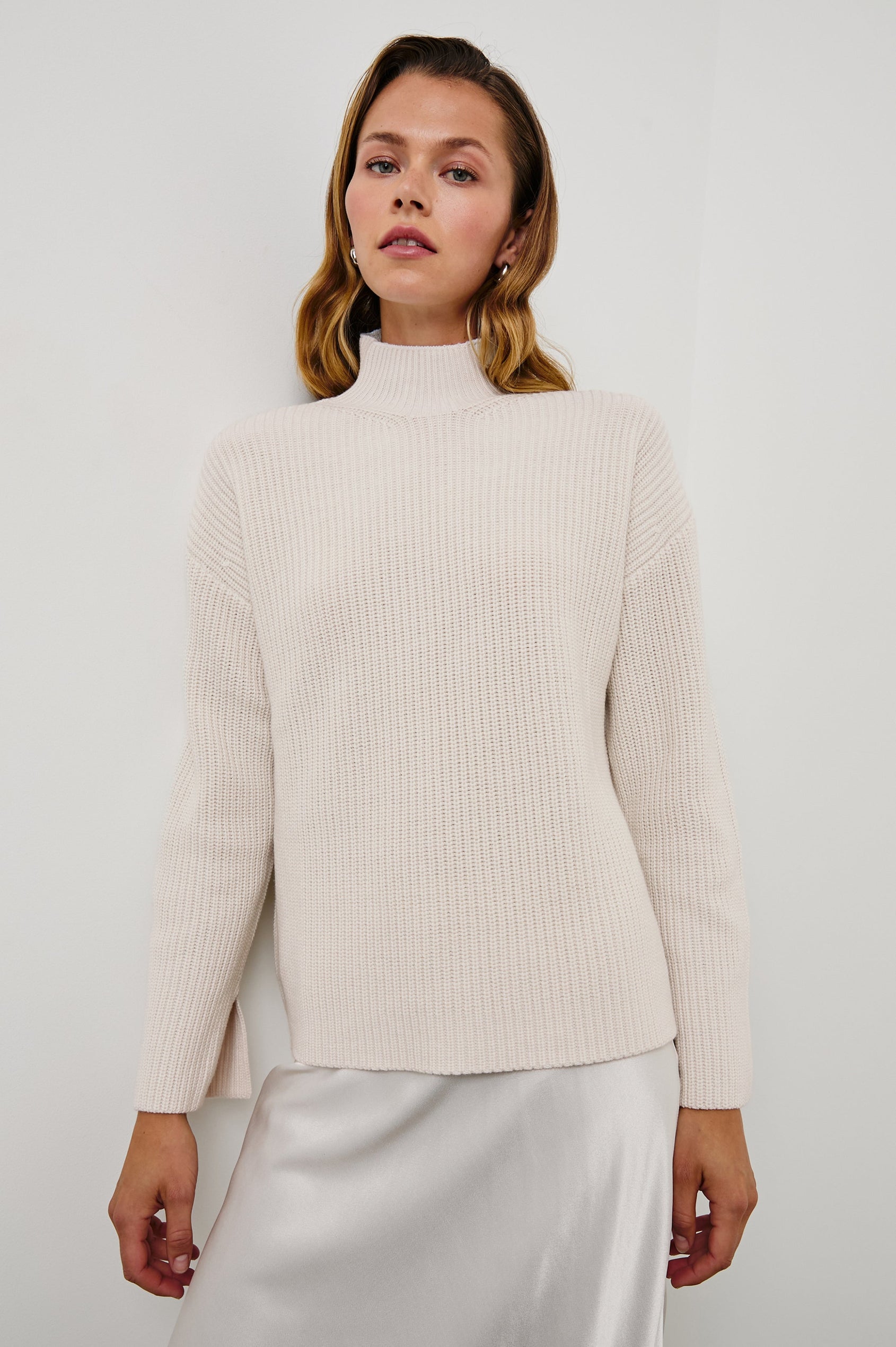 Sanna Long Sleeve Knit Sweater with a Funnel Neck and Slits at the Back of the Neck and on the Cuffs in Hazy Dust Colorway - Front View Featured on Model
