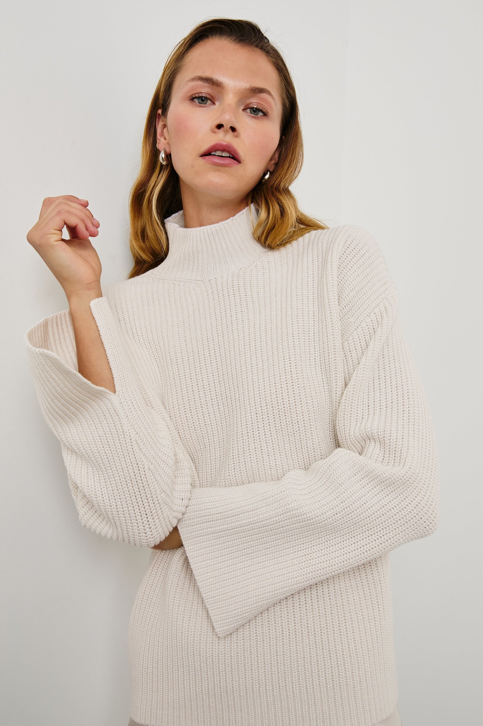 Sanna Long Sleeve Knit Sweater with a Funnel Neck and Slits at the Back of the Neck and on the Cuffs in Hazy Dust Colorway - Front View Featured on Model