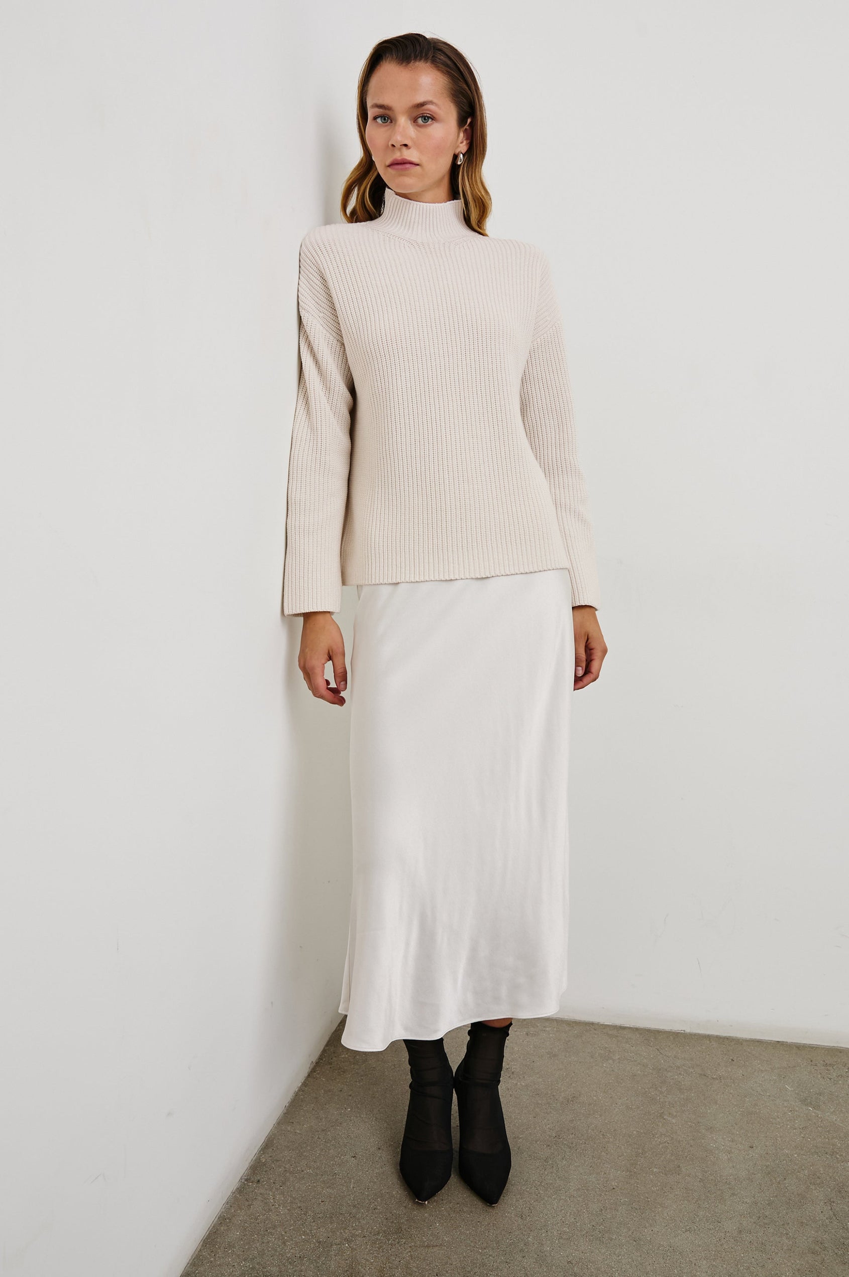 Sanna Long Sleeve Knit Sweater with a Funnel Neck and Slits at the Back of the Neck and on the Cuffs in Hazy Dust Colorway - Front Full Body View Featured on Model