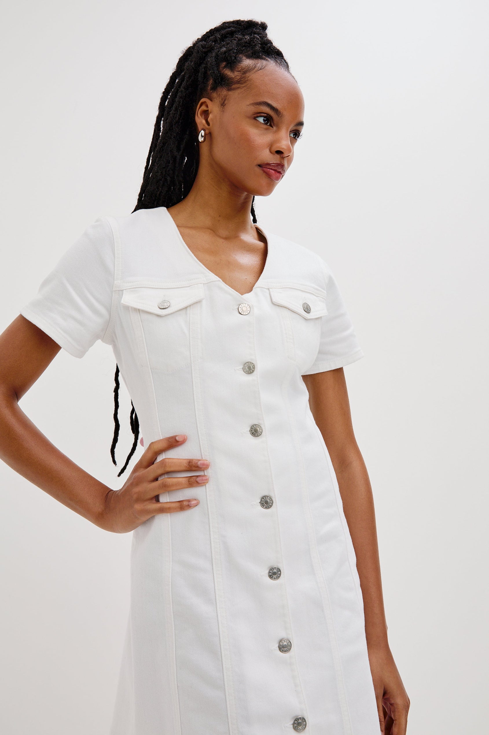 Saratoga Mini Denim Dress with a V-Neck, Short Sleeves, Button Front, Chest Flap Pockets in Salt White Colorway. Front View Shown on Model.