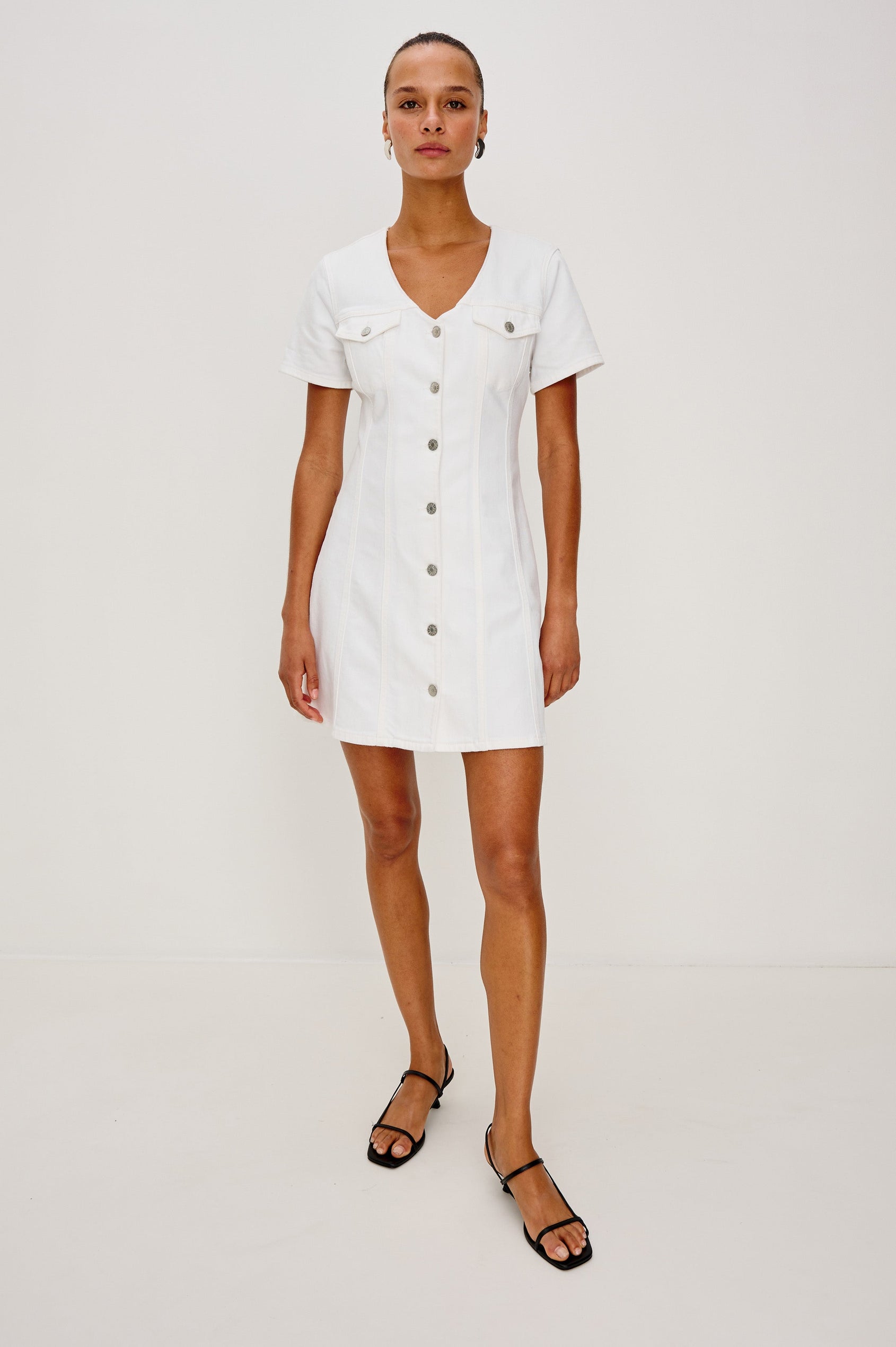 Saratoga Mini Denim Dress with a V-Neck, Short Sleeves, Button Front, Chest Flap Pockets in Salt White Colorway. Front View Shown on Model.