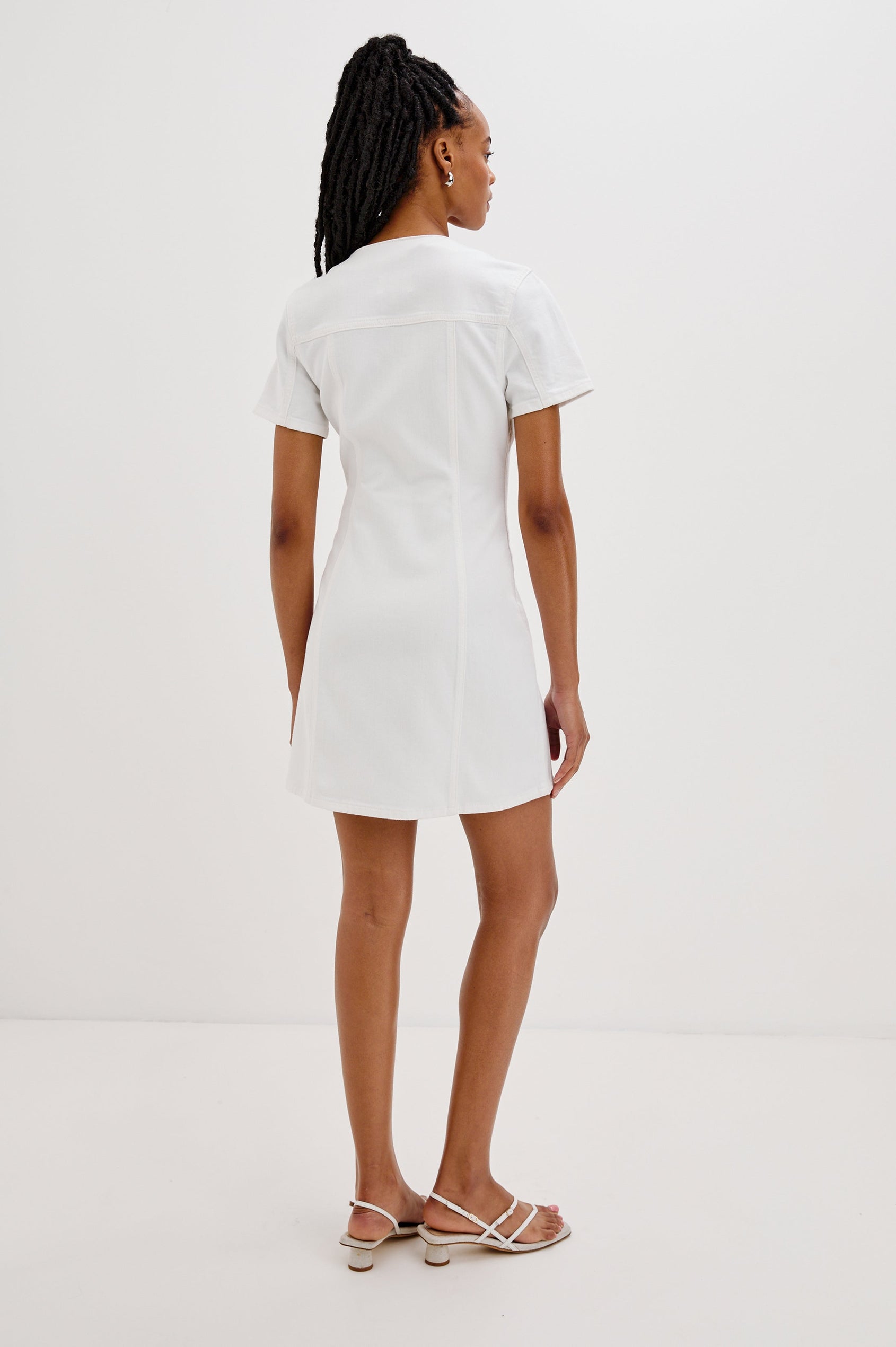 Saratoga Mini Denim Dress with a V-Neck, Short Sleeves, Button Front, Chest Flap Pockets in Salt White Colorway. Back View Shown on Model.