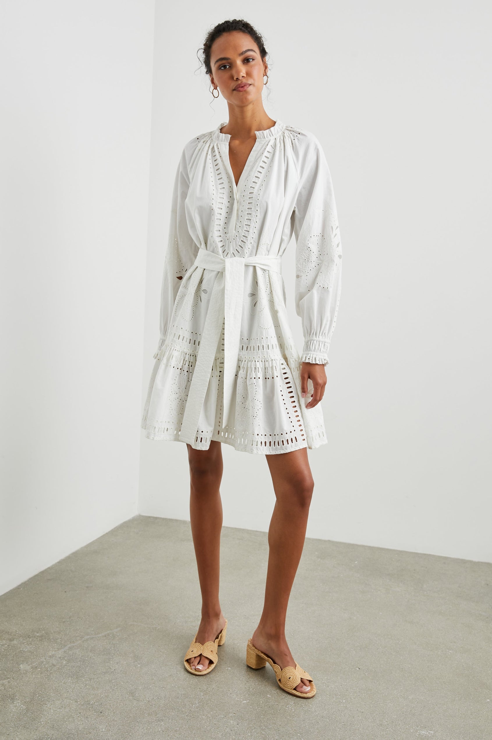 Saylor Long-Sleeve Midi Dress with a Half-Sealed Placket, a V Neck, Ruffled Collar with Shirring, a Fabric Tie Belt, and Floral and Geometric Eyelet Details in White Colorway - Front Full Body View Featured on Model 