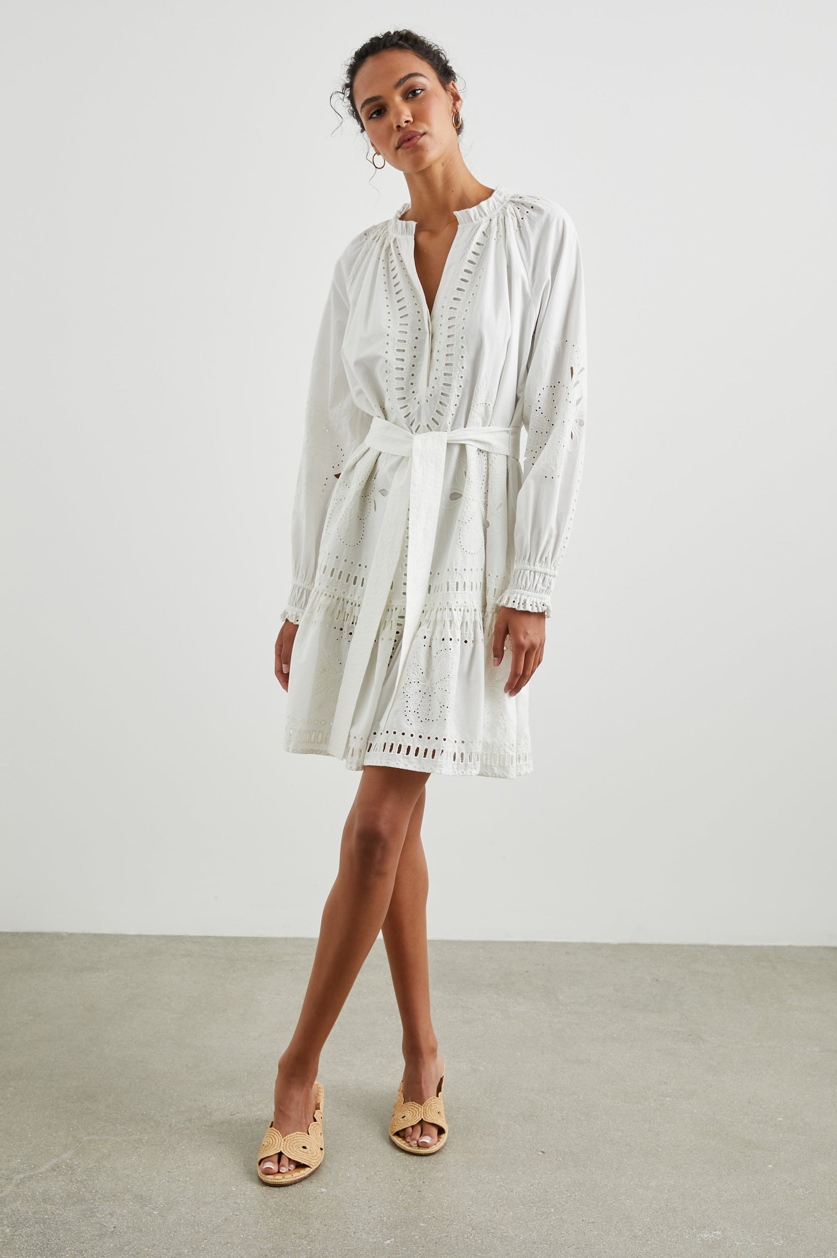 Saylor Long-Sleeve Midi Dress with a Half-Sealed Placket, a V Neck, Ruffled Collar with Shirring, a Fabric Tie Belt, and Floral and Geometric Eyelet Details in White Colorway - Front Full Body View Featured on Model 