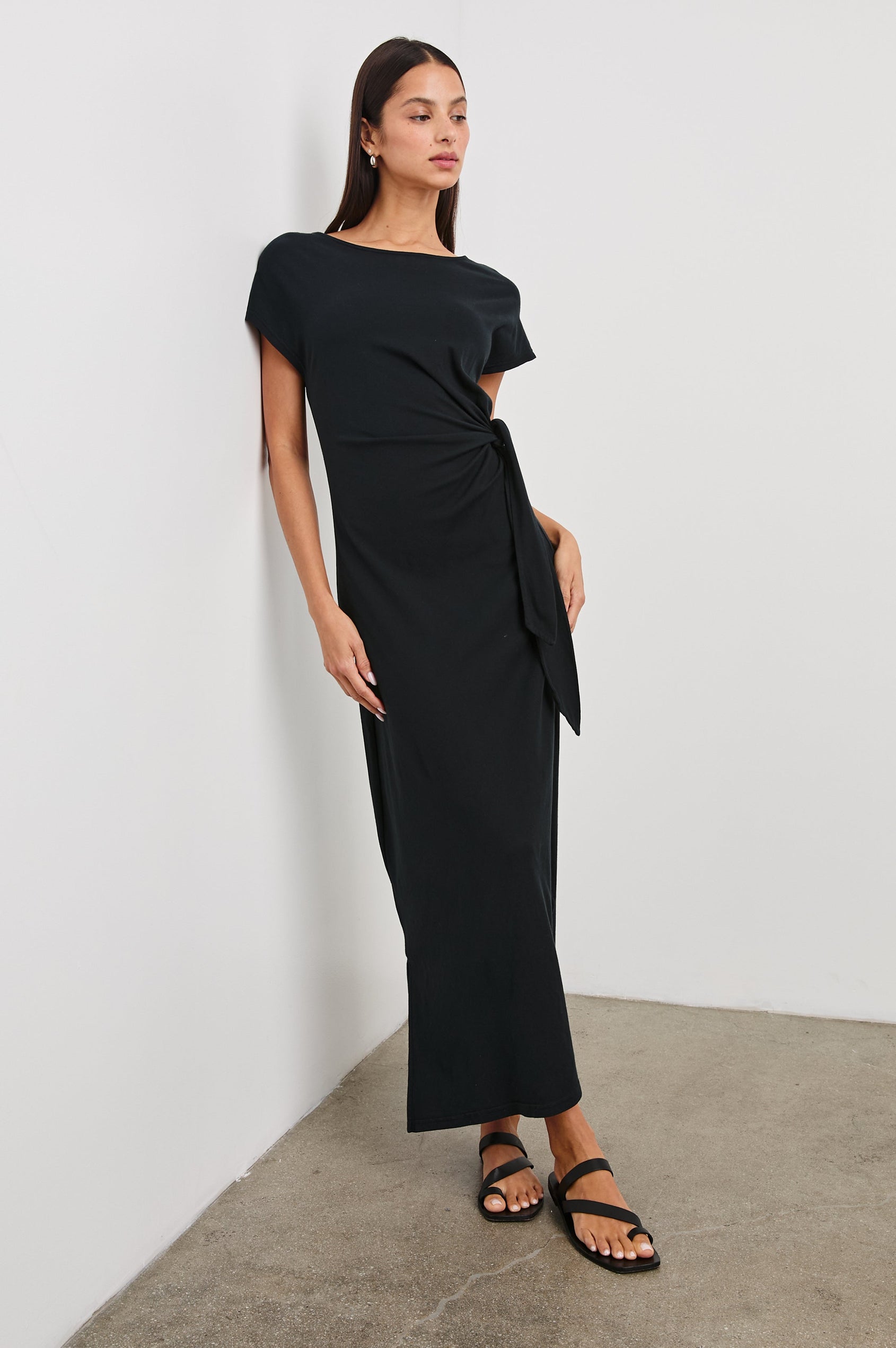 Selah Maxi Dress with Short Sleeves, Boatneck, Adjustable Side Tie at Waist and Two Mid-Calf Side Slits in Black Colorway  - Front Full Body View Featured on Model