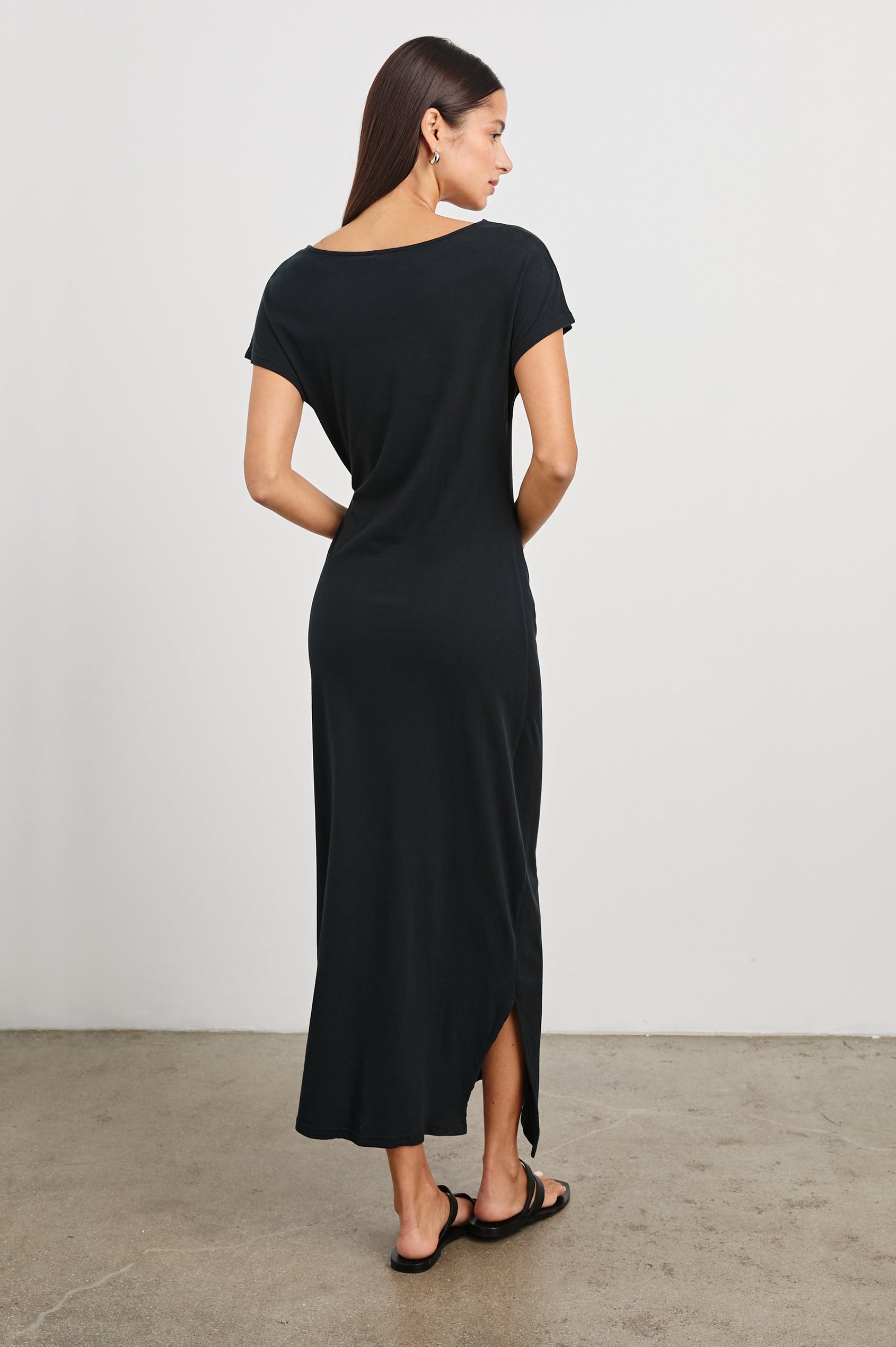 Selah Maxi Dress with Short Sleeves, Boatneck, Adjustable Side Tie at Waist and Two Mid-Calf Side Slits in Black Colorway  - Back Full Body View Featured on Model