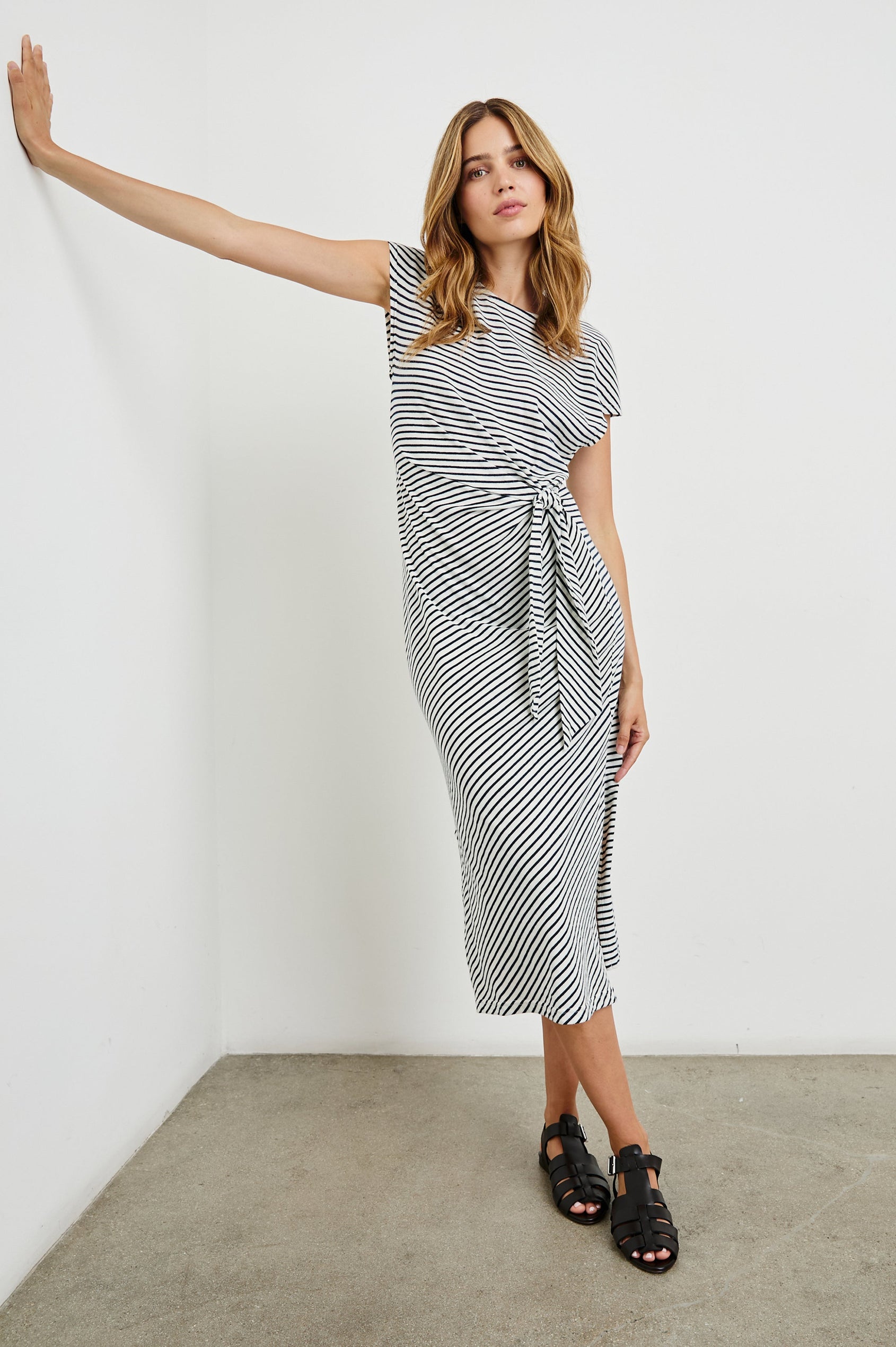 Selah Maxi Dress with Short Sleeves, Boatneck, Adjustable Side Tie at Waist and Two Mid-Calf Side Slits in Black Colorway  - Front Full Body View Featured on Model