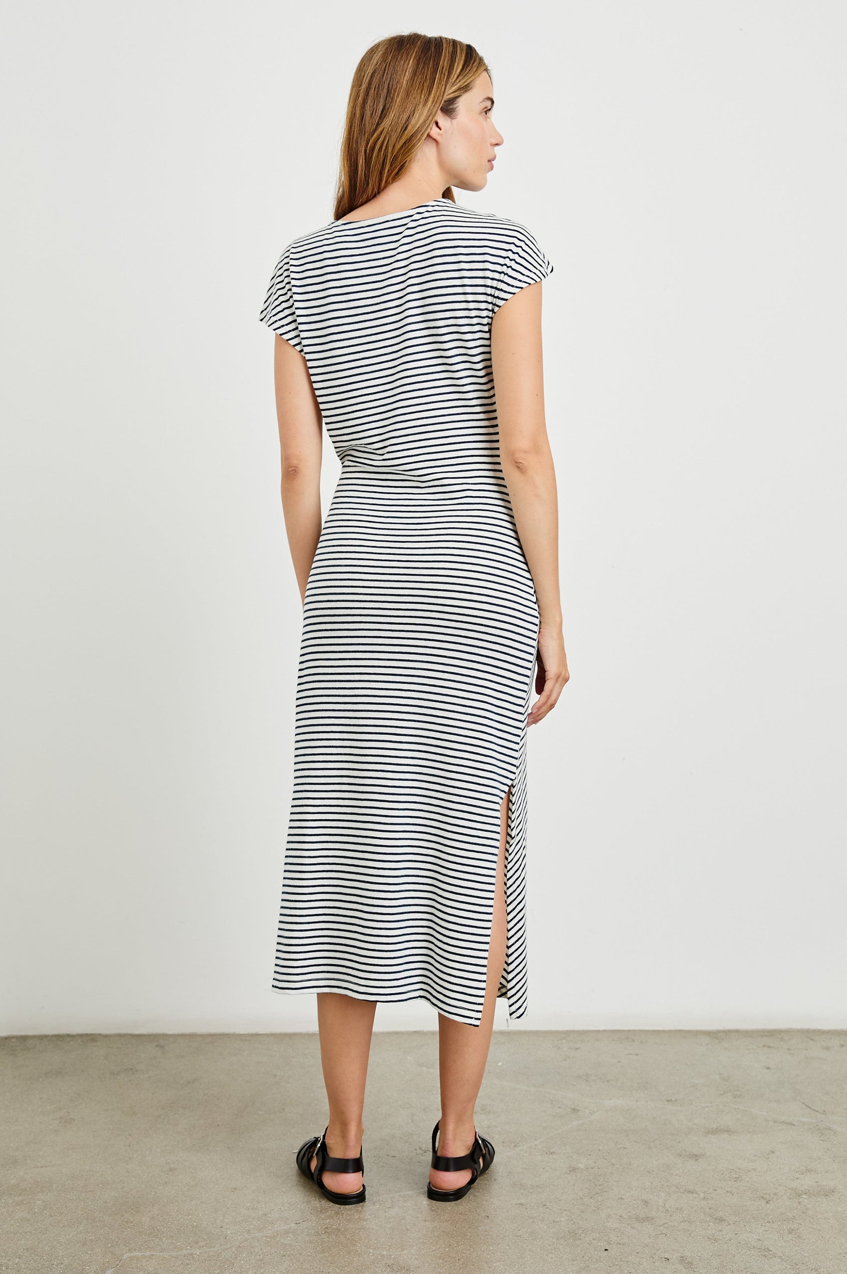 Selah Maxi Dress with Short Sleeves, Boatneck, Adjustable Side Tie at Waist and Two Mid-Calf Side Slits in Black Colorway  - Back Full Body View Featured on Model