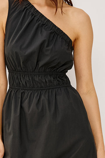 Selani Midi Dress With an Asymmetrical Neckline, Mid-Thigh Slide Slit and Cinched Waistband in Black Colorway - Front Full Body View Featured on Model