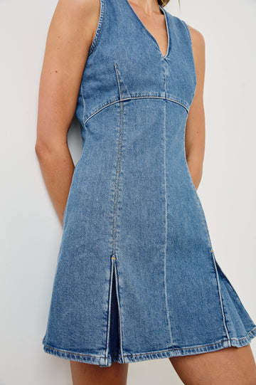 Serra fitted v-neck denim mini dress with pleated skirt in light wash Bristol -  close up of details on model