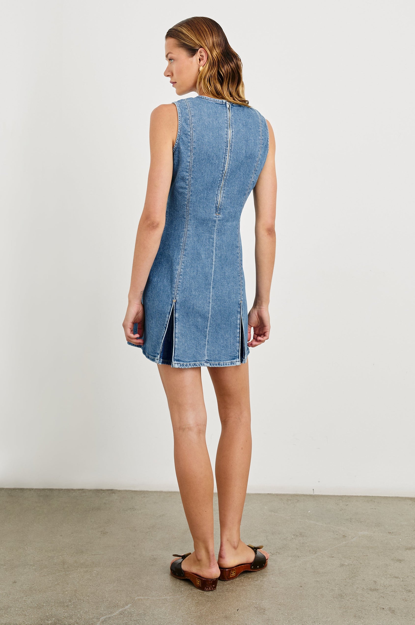 Serra fitted v-neck denim mini dress with pleated skirt in light wash Bristol - back view on model