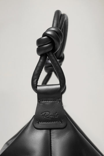 Siena Slouchy Hobo Bag in Italian Leather With Knotted Top Strap, Zipper Closure With Fringe Tassel And Interior Snap Button Slip Pocket in Black Colorway - Close Up Side View Branded Detail Featured