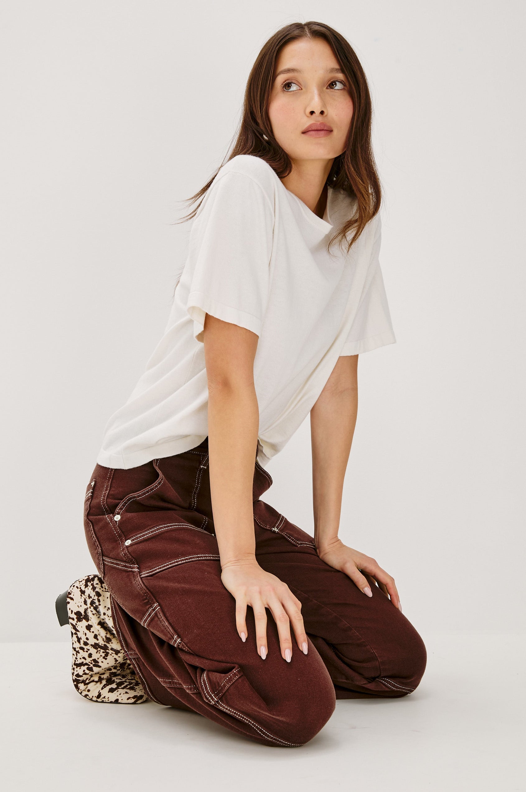 Silverado high rise wide leg crop pant with carpenter style details and contrast stitching in Chocolate Contrast Stitch - side kneeling view on model.