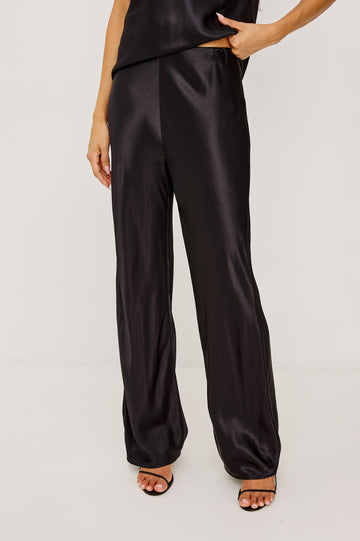 Silvi High-Waisted Pant in Metallic Satin Back Crepe With Elastic Waistband and Straight Legs in Black Colorway - Lower Body Front View Featured on Model