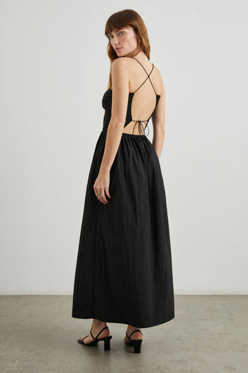 Silvia Sleeveless Maxi Dress with Spaghetti Straps with a Lower Back Tie, an Open Back, and Cutouts Along the Center of the Bodice in Black Nylon Colorway - Back Full Body View Featured on Model
