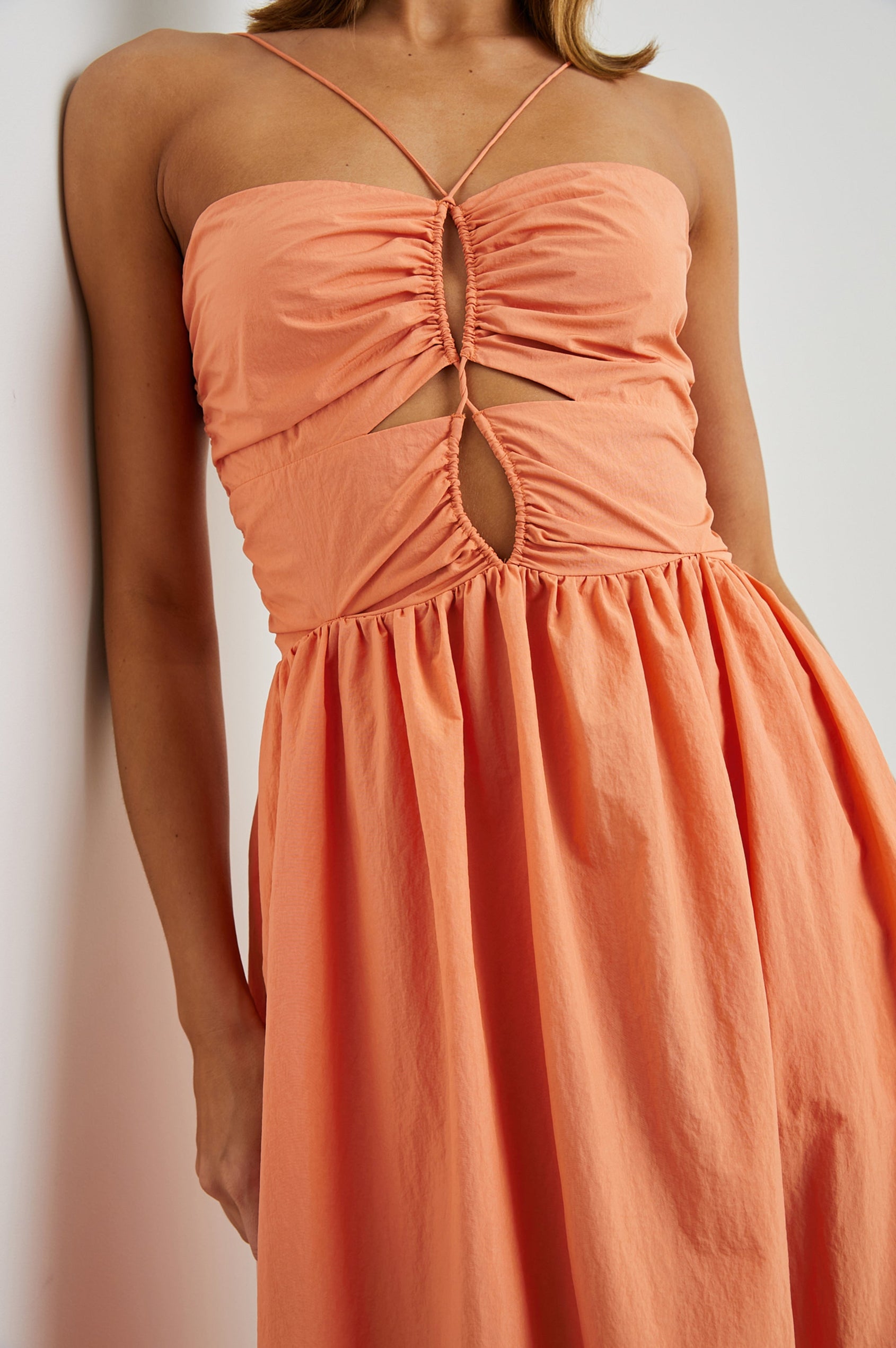 Silvia Sleeveless Maxi Dress with Spaghetti Straps with a Lower Back Tie, an Open Back, and Cutouts Along the Center of the Bodice in Papaya Colorway - Front View Featured on Model