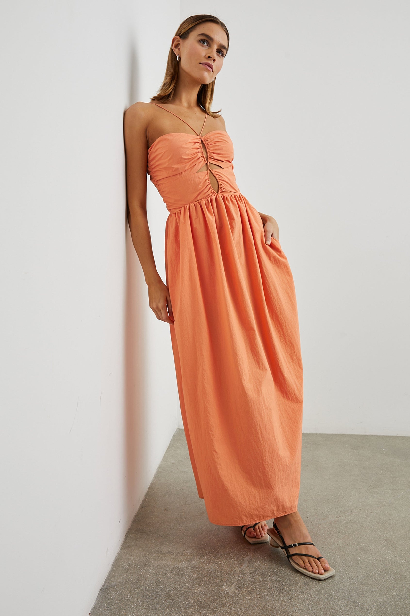 Silvia Sleeveless Maxi Dress with Spaghetti Straps with a Lower Back Tie, an Open Back, and Cutouts Along the Center of the Bodice in Papaya Colorway - Front Full Body  View Featured on Model