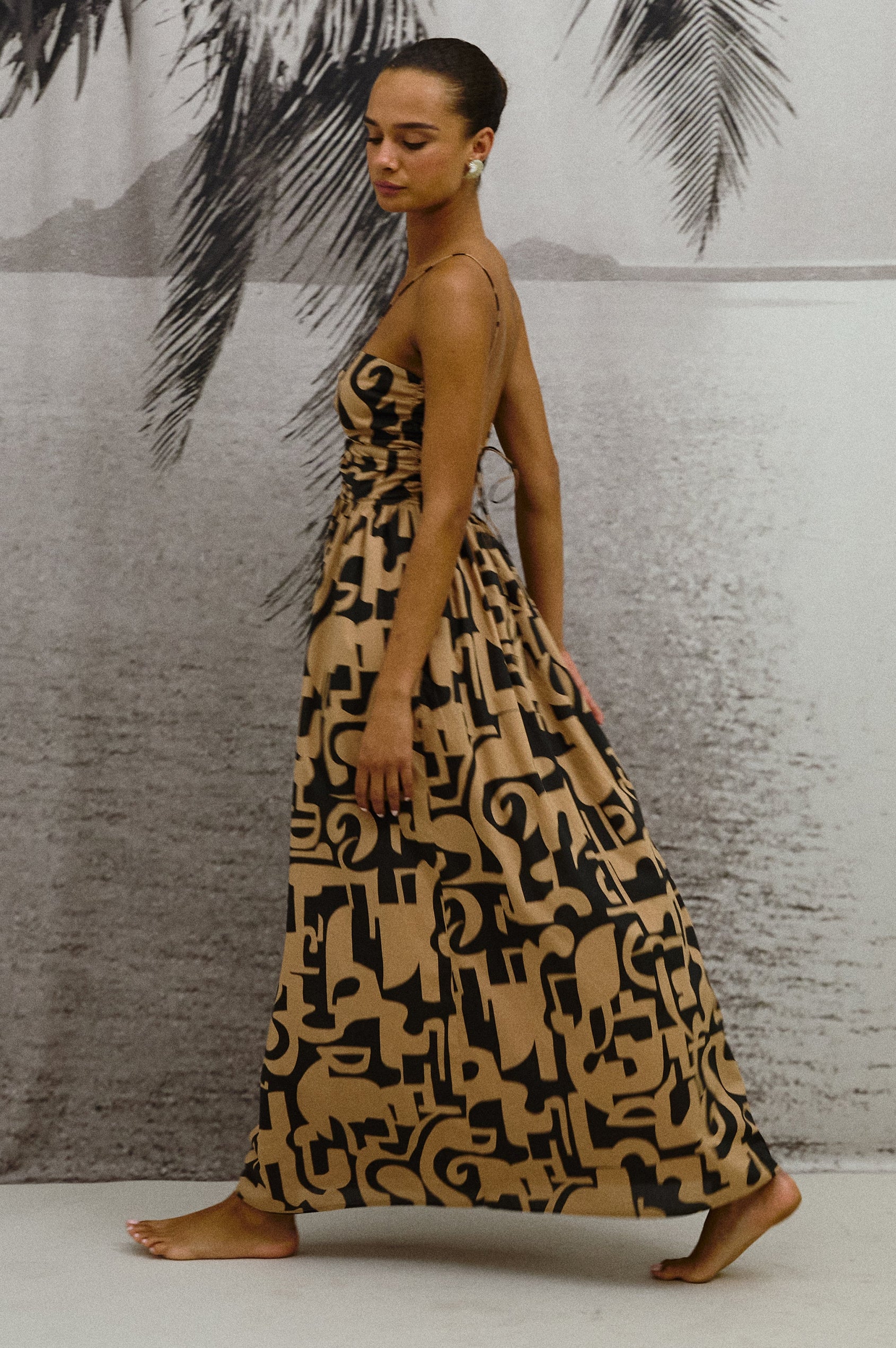 Silvia Dress, tan and black pattern in Santorini Sand with skinny straps and front cutouts - side view on model in motion