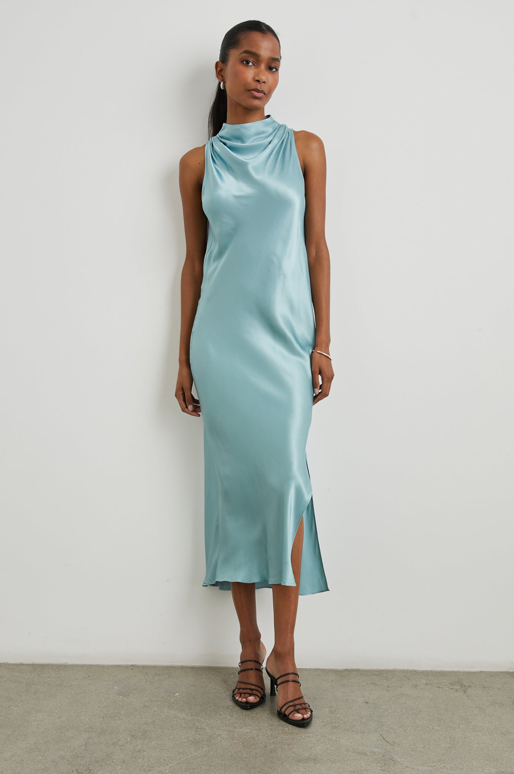 Solana Sleeveless Midi Dress with a High Cowl Collar, Side Slit, and Two Button Keyhole Closure at the Back in Clearwater Colorway, a Blue - Front Full Body View Featured on Model