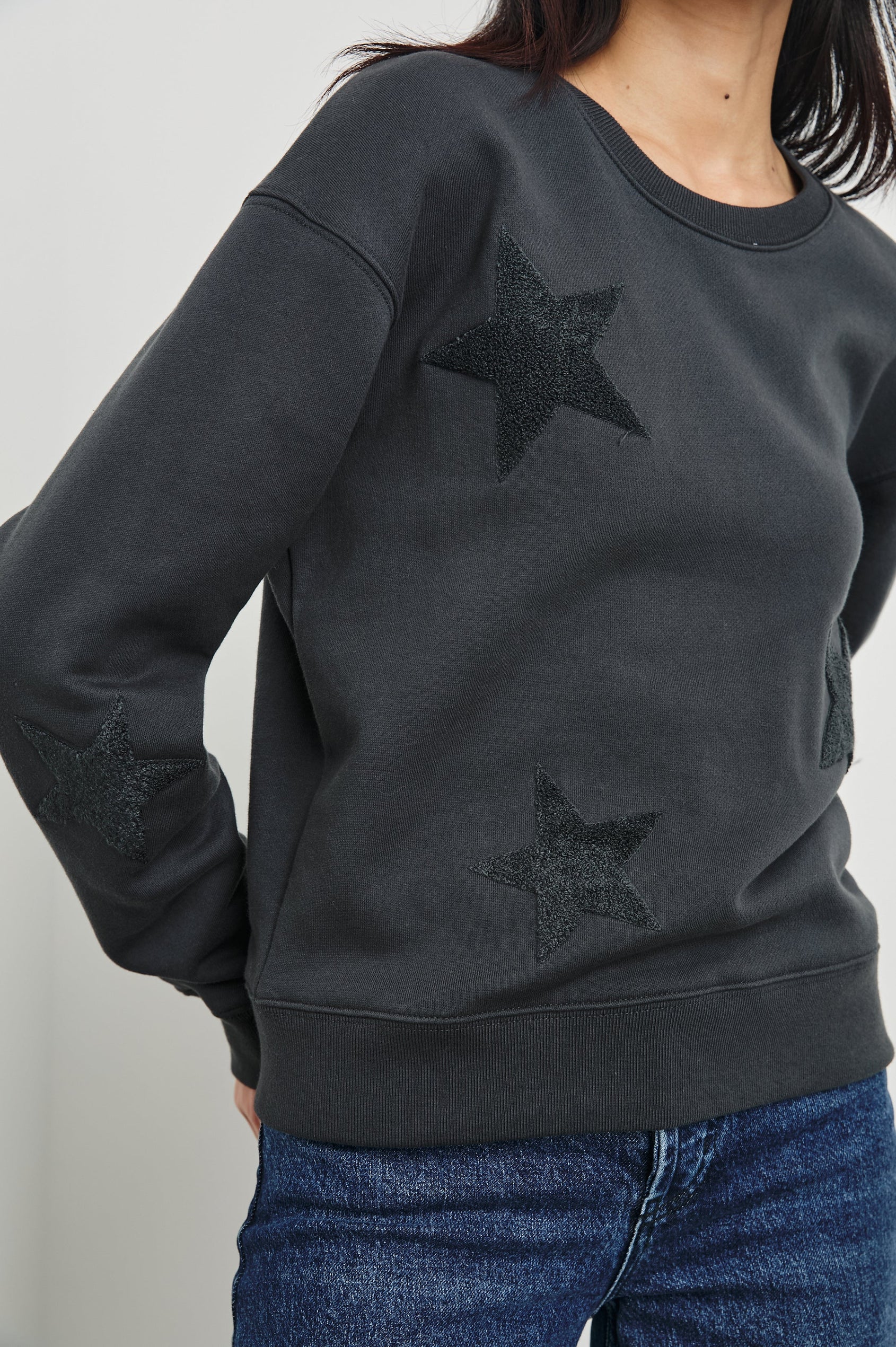 Sonia Long-Sleeve Sweatshirt with a Crew Neck and Charcoal Patch Stars in Washed Black Colorway - Front View Featured on Model