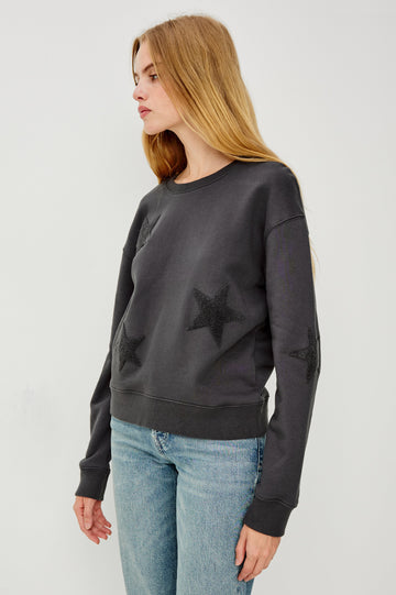Sonia Long-Sleeve Sweatshirt with a Crew Neck and Charcoal Patch Stars in Washed Black Colorway - Side View Featured on Model