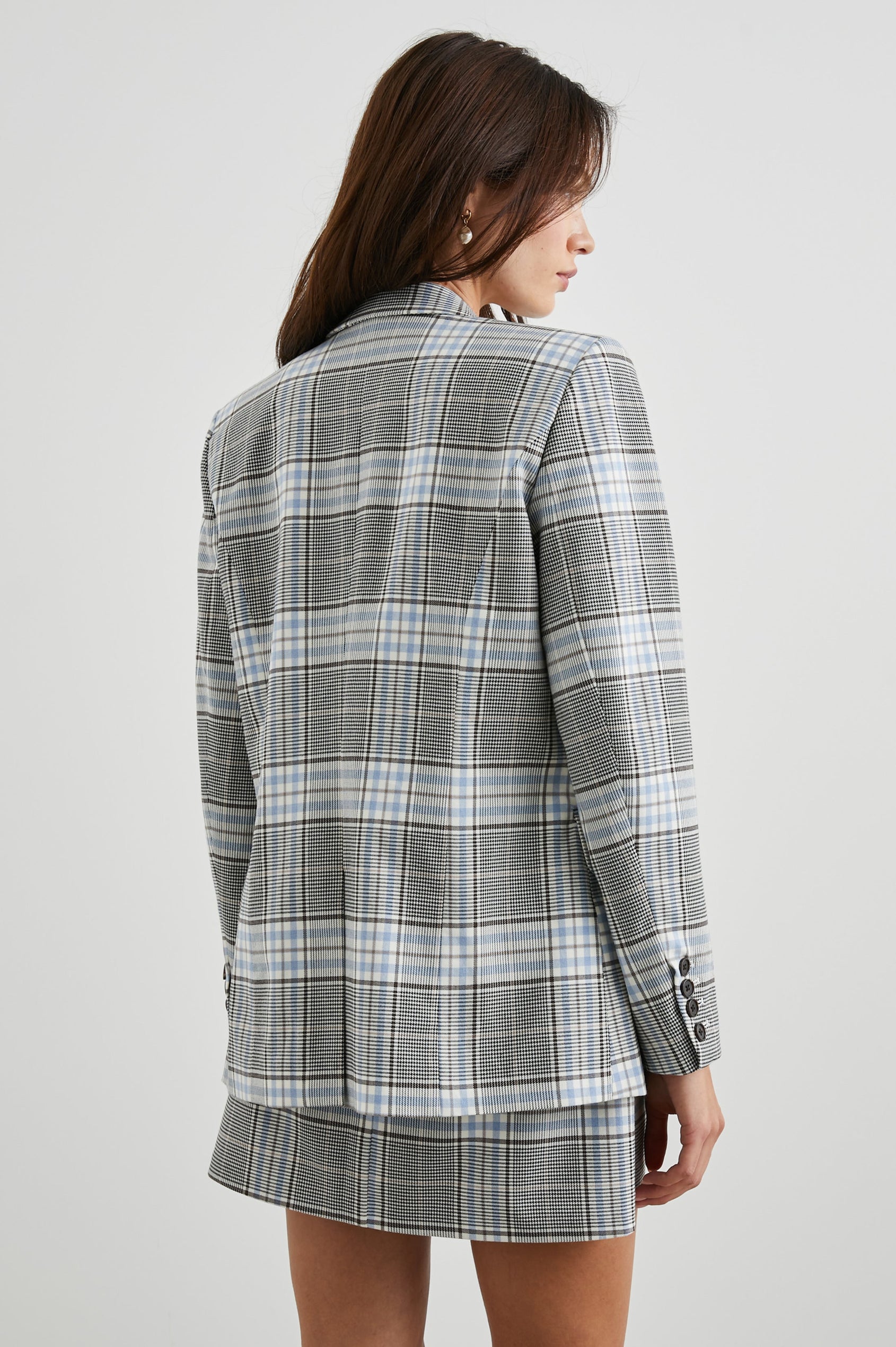 Stanton Blazer with Two Button Closure, Two Front Flap Pockets, a Chest Patch Pocket and Four-Button Cuffs in Cocoa Sky Check Colorway, a Grey, Blue and White Plaid - Back View Featured on Model