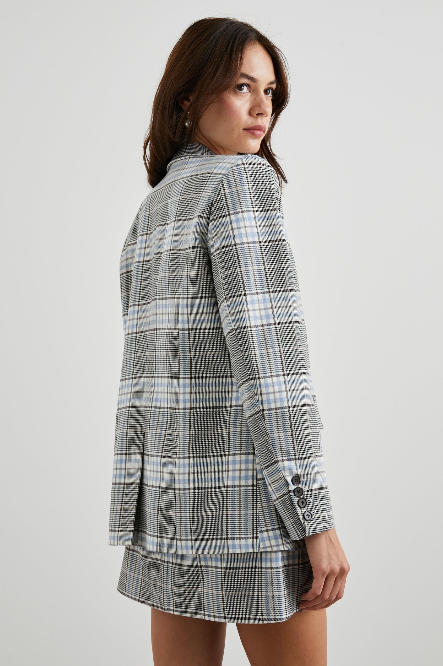 Stanton Blazer with Two Button Closure, Two Front Flap Pockets, a Chest Patch Pocket and Four-Button Cuffs in Cocoa Sky Check Colorway, a Grey, Blue and White Plaid - Back View Featured on Model