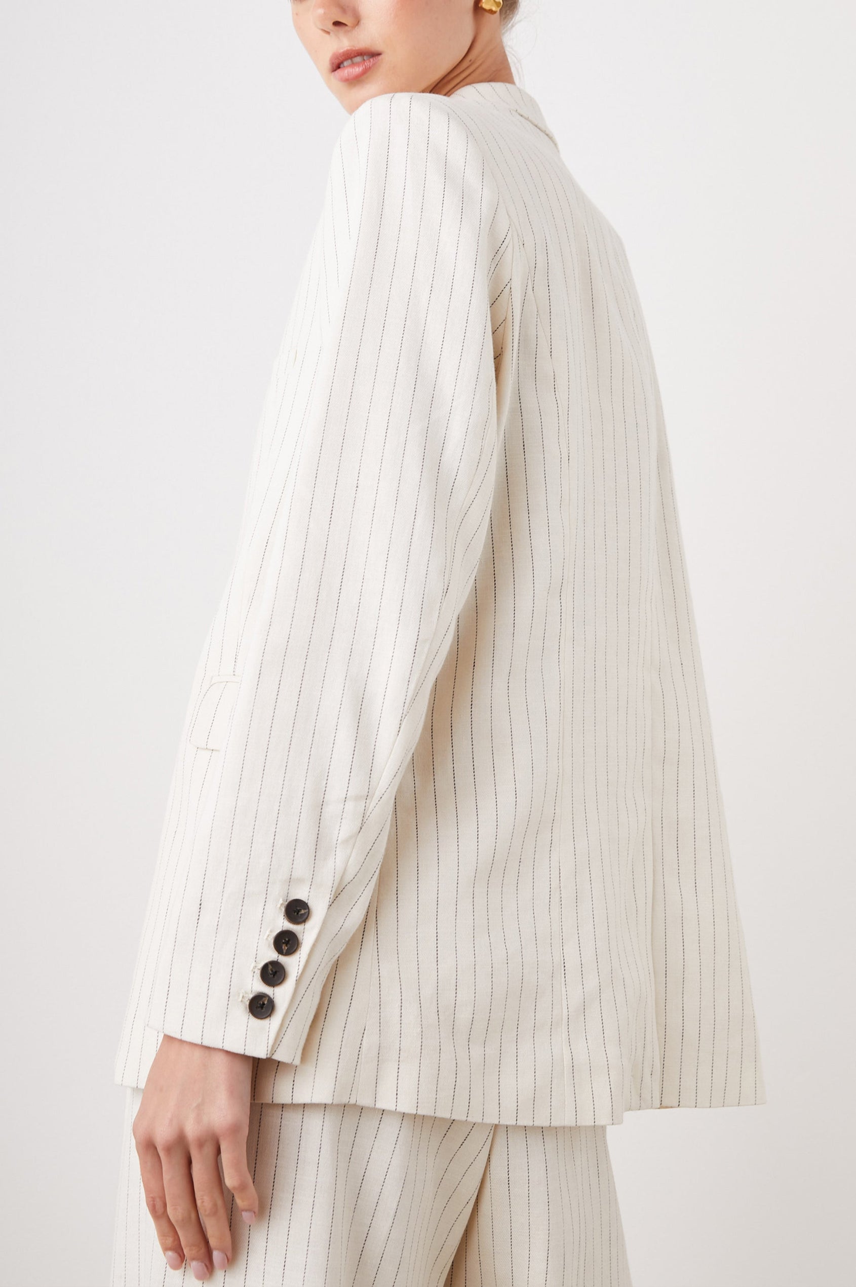 Stanton Blazer with Two Button Closure, Two Front Flap Pockets, a Chest Patch Pocket and Four-Button Cuffs in Ivory Pinstripe Colorway - Side View Featured on Model