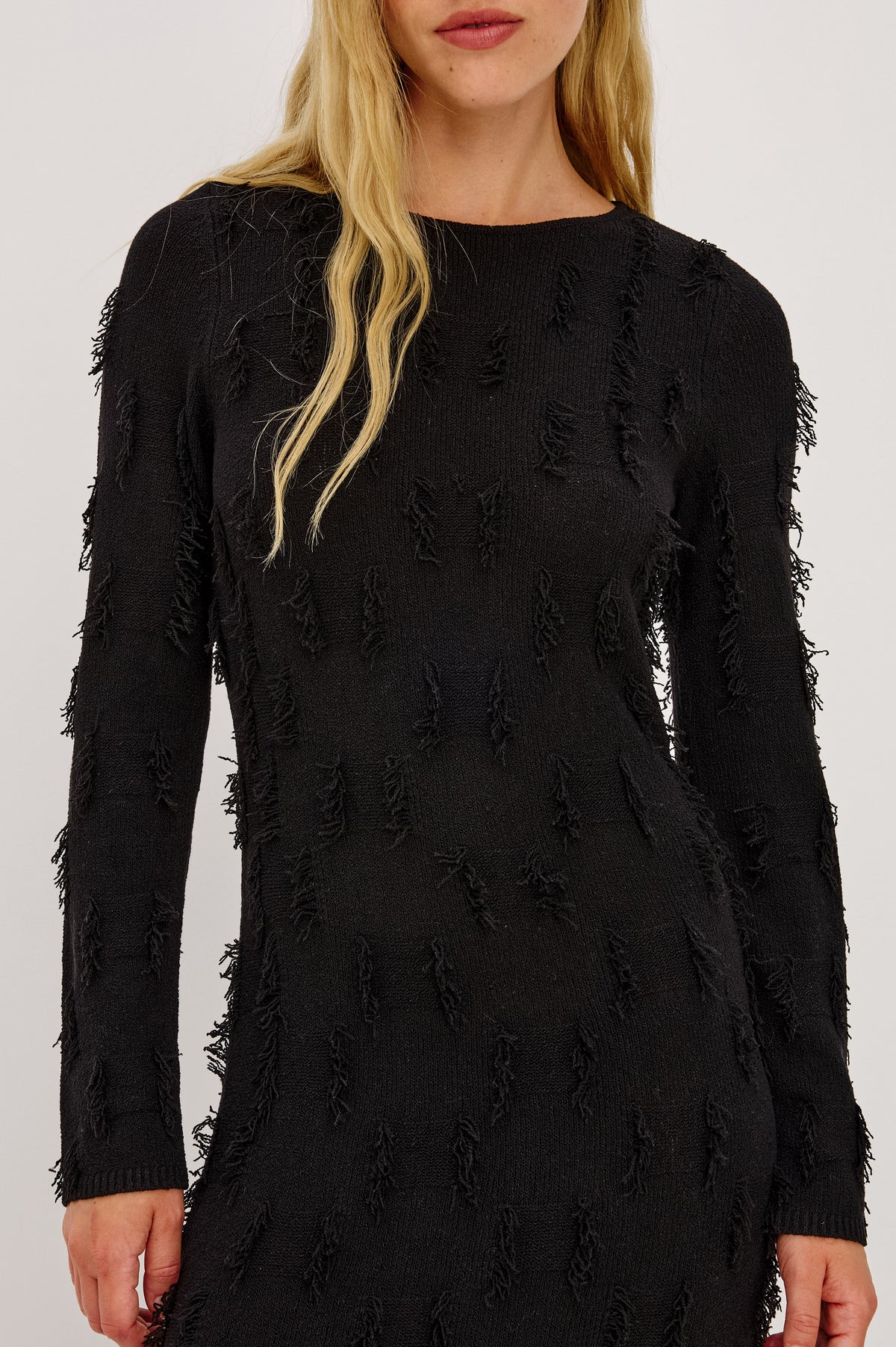 Sulma Maxi Dress Knit in Soft Fine-Gauge Yarn With Alover Fringe, Slim Fit Through Bodice and Long Sleeves, and A-Line Skirt in Black Colorway - Front Crop Detail View Featured on Model.